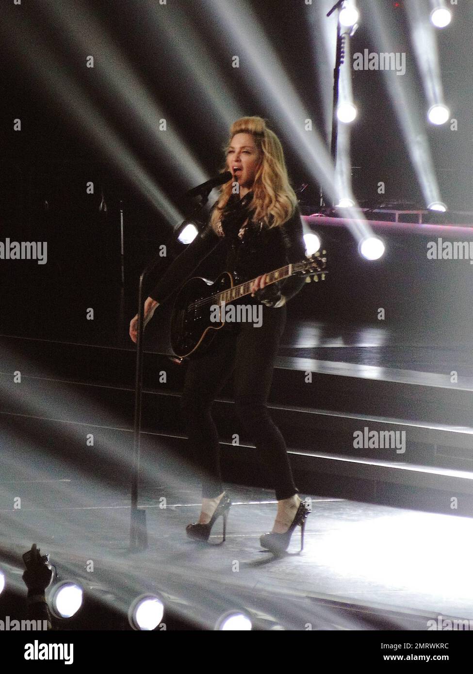 Madonna tritt während ihrer MDNA Tour im Staples Center live in einem Konzert auf. Während der Show Madonna spielte eine Reihe klassischer Lieder mit neueren Hits aus ihrem „MDNA“-Album und ihre Kostüme reichten von einem gefesselten Gefangenen, der von maskierten Milizen und einer Trommelmajorette begleitet wurde, bis hin zu einem klassischen, eleganten Look mit Hosen und Krawatte und einem maßgeschneiderten Korsett komplett mit dem ikonischen Kegel BH. An einem Punkt während der Show, entblößte Madonna ihren mit Fischnetz verkleideten Hintern vor Publikum. Damit war Madonnas erste von zwei LA-Darbietungen, die Tour, die bisher kontrovers war, mit berichteten offenbaren B. Stockfoto