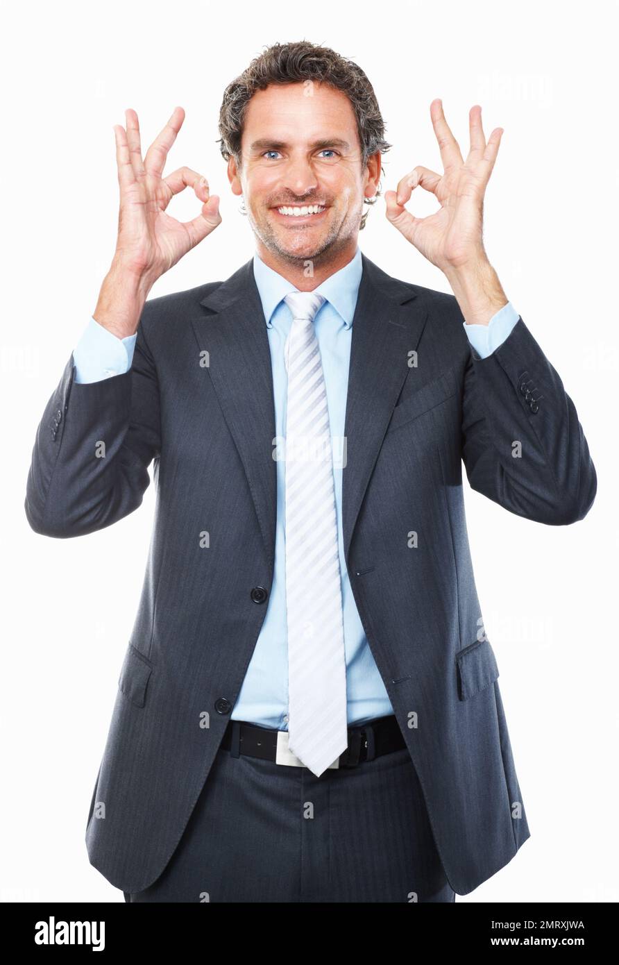 Die Geschäftsleitung gibt das OK-Schild. Porträt eines lächelnden Geschäftsmanns, der ein OK-Zeichen vor weißem Hintergrund gibt. Stockfoto