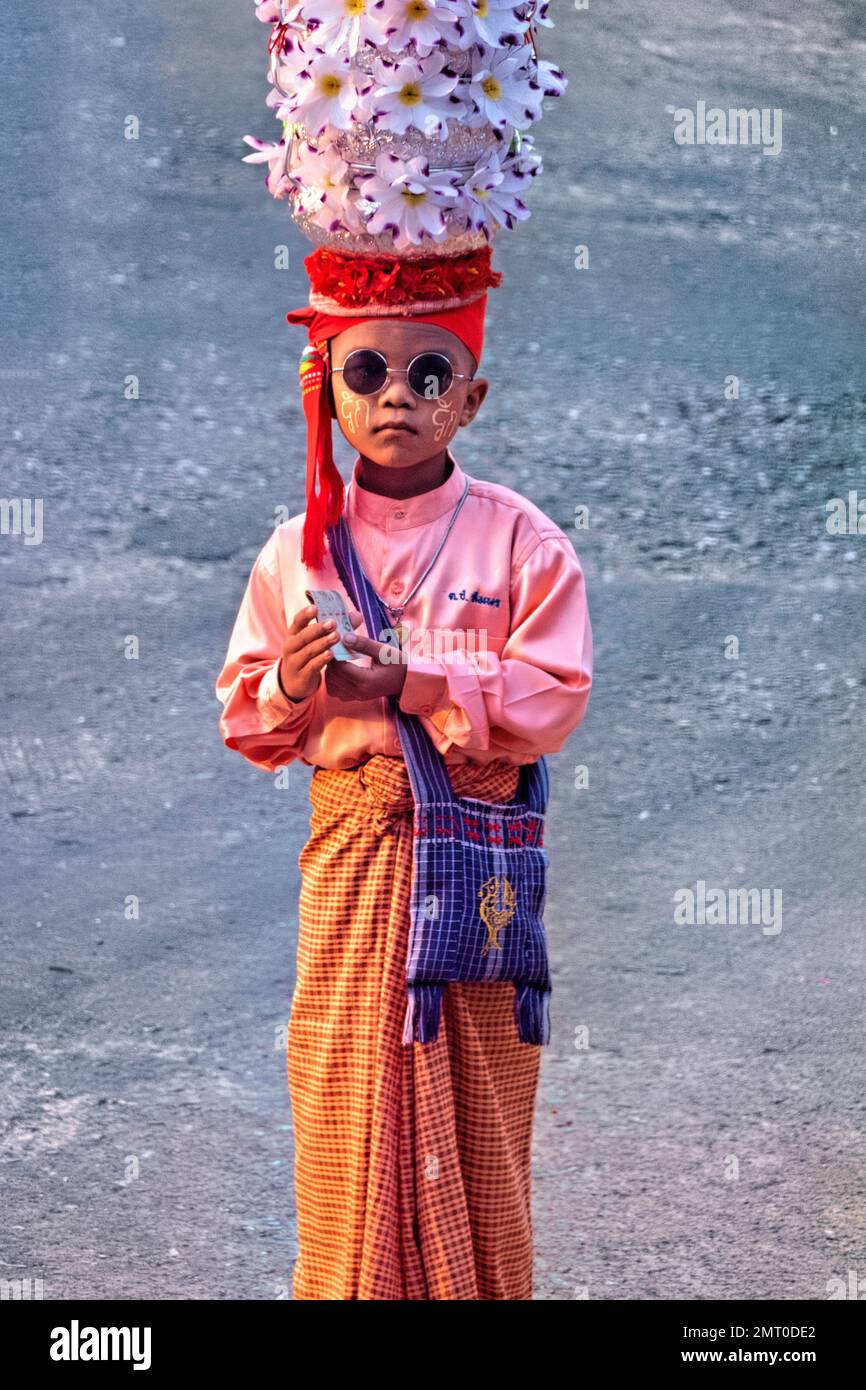 Mon Boy in traditioneller Kleidung während der morgendlichen Almosenzeremonie in Sangkhlaburi, Thailand Stockfoto