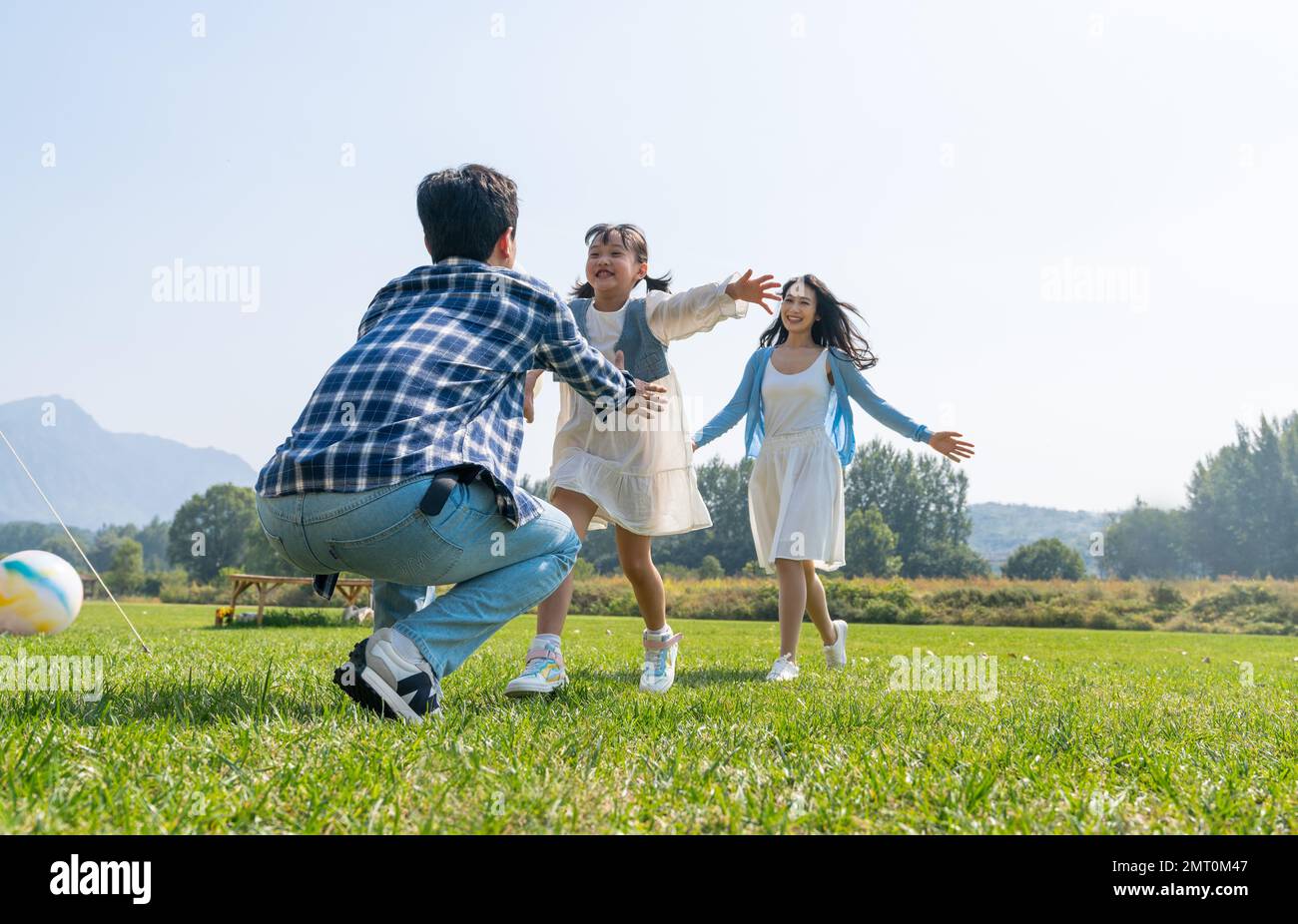 Meine Mutter und meine Tochter liefen glücklich in die Arme meines Vaters Stockfoto