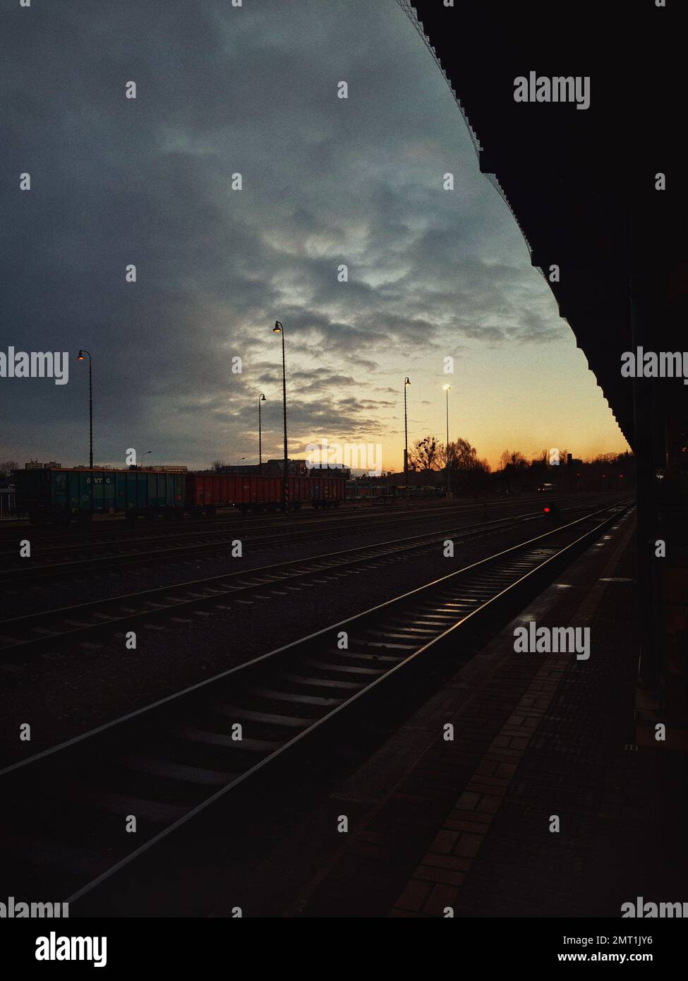 Ein vertikaler Schuss von Bahnschienen bei Sonnenuntergang Stockfoto