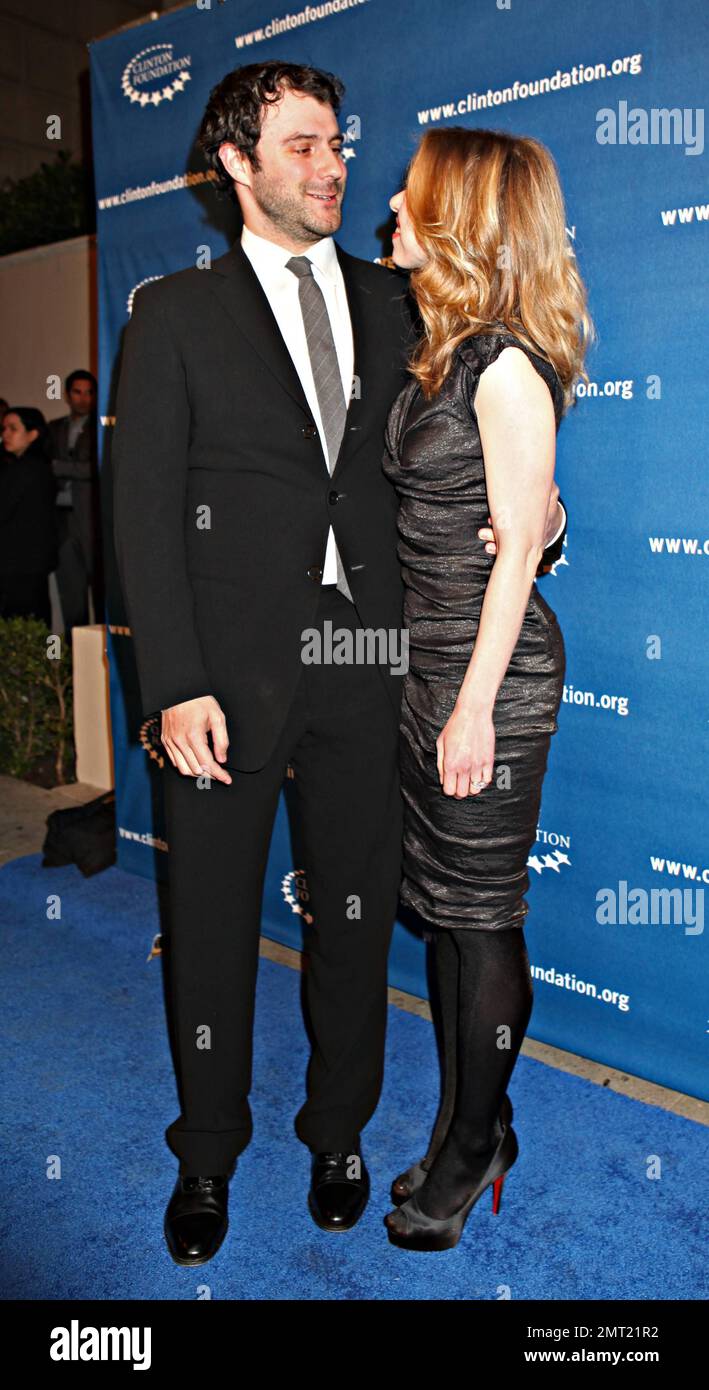In einem schmaleren schwarzen Cocktailkleid strahlt Chelsea Clinton, während sie mit ihrem Ehemann Marc Mezvinsky auf dem blauen Teppich Händchen hält, während der vom ehemaligen US-Präsidenten Bill Clinton auf dem Boulevard 3 veranstaltete Millennium Network Event stattfindet. Los Angeles, Kalifornien. 03/17/11. Stockfoto
