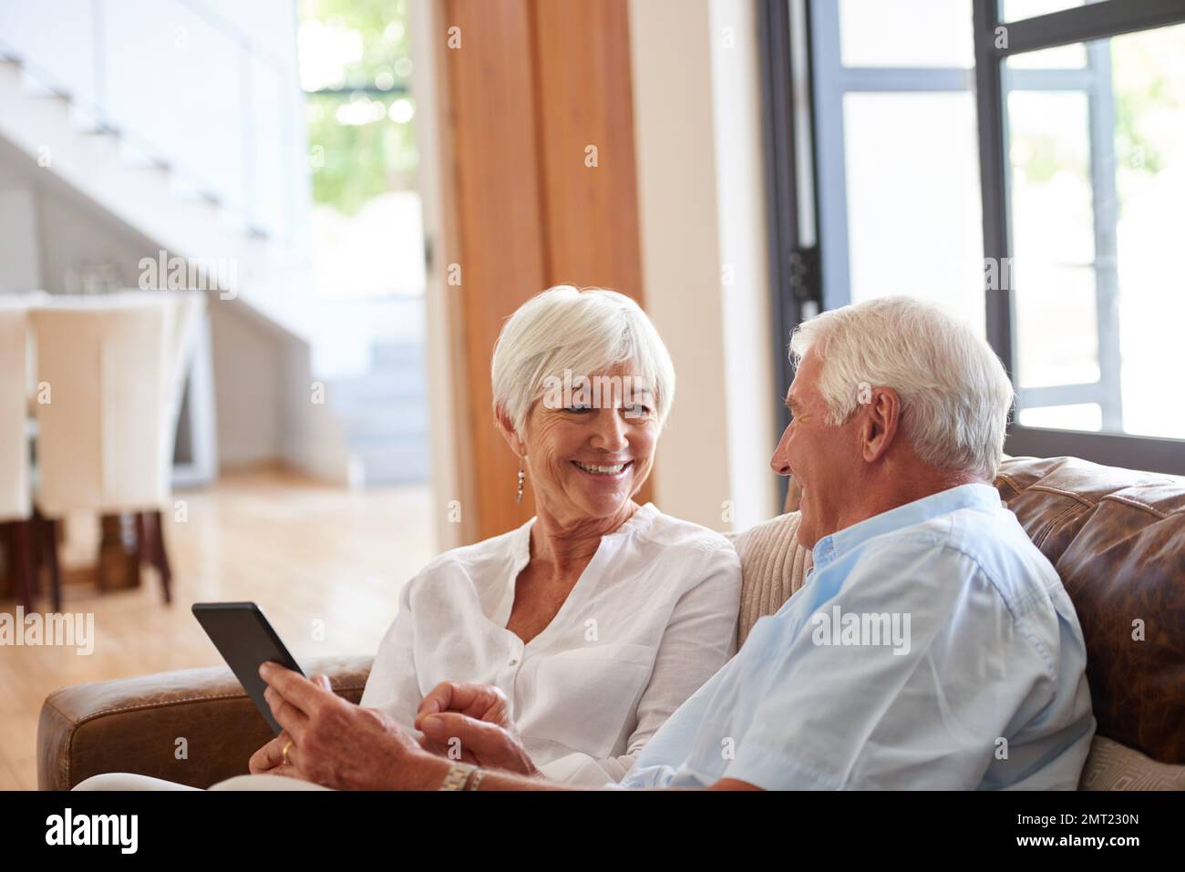 Wie cool ist dieser Honig. Ein älteres Paar, das zu Hause ein digitales Tablet verwendet. Stockfoto