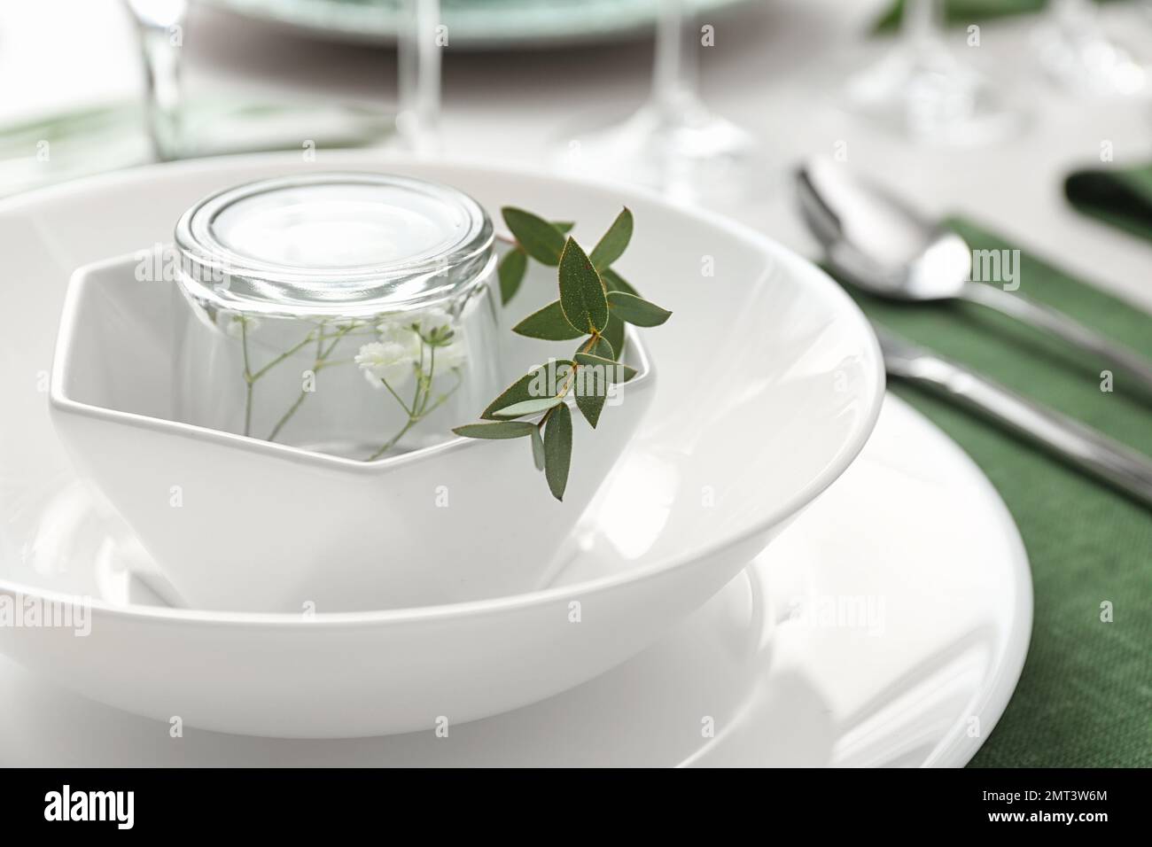 Stilvolles Geschirr mit grünen Blättern auf dem Tisch, Nahaufnahme.  Festliches Ambiente Stockfotografie - Alamy