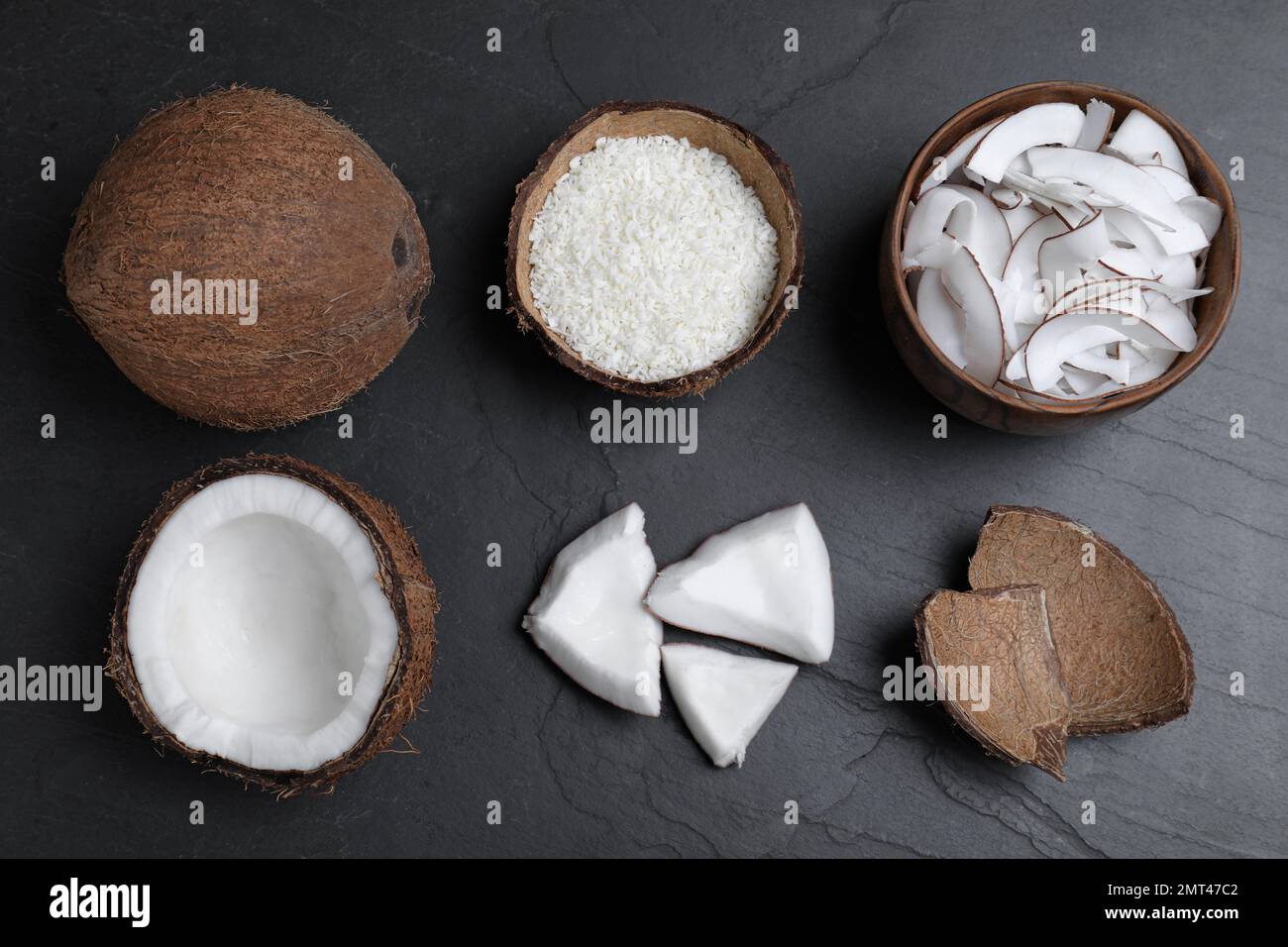 Flache Laienzusammensetzung mit frischen Kokosflocken auf schwarzem Tisch Stockfoto