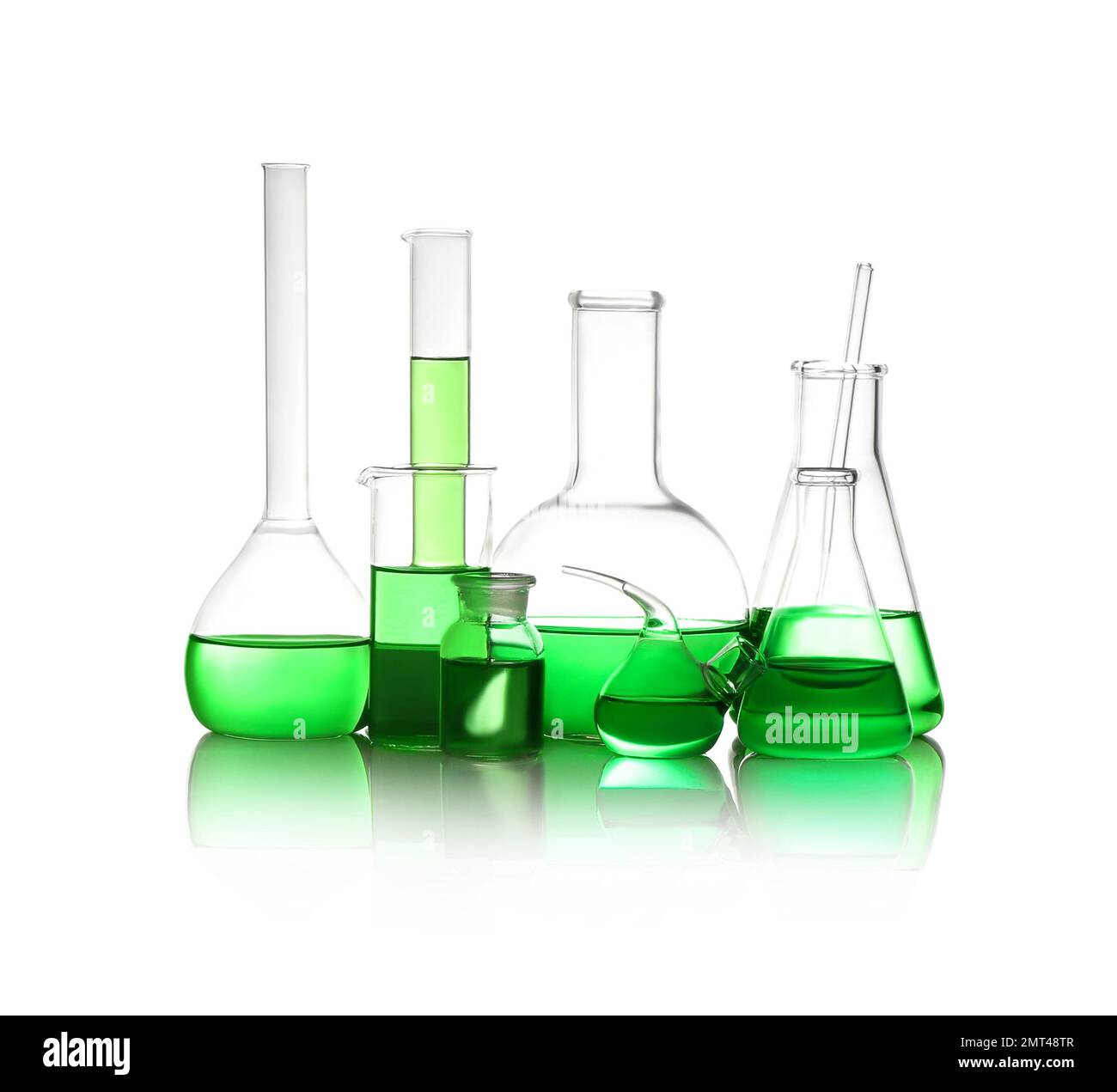Verschiedene Laborglasgeräte mit hellgrüner Flüssigkeit, isoliert auf weiß Stockfoto