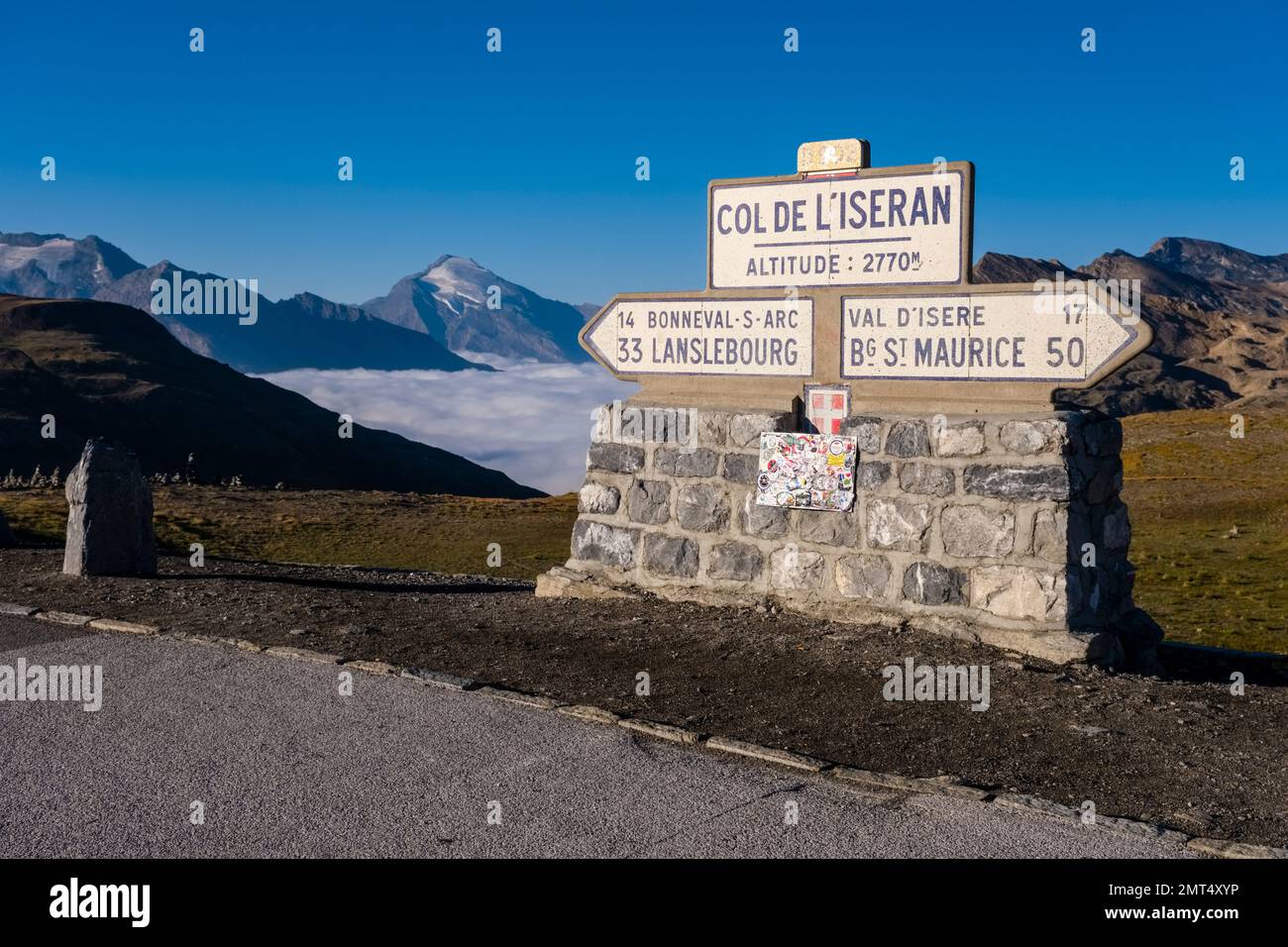 Wegweiser auf Col de L'Iseran 2770 m, der höchste befestigte Pass in den Alpen, Berge und Hügel der Graischen Alpen in der Ferne. Stockfoto
