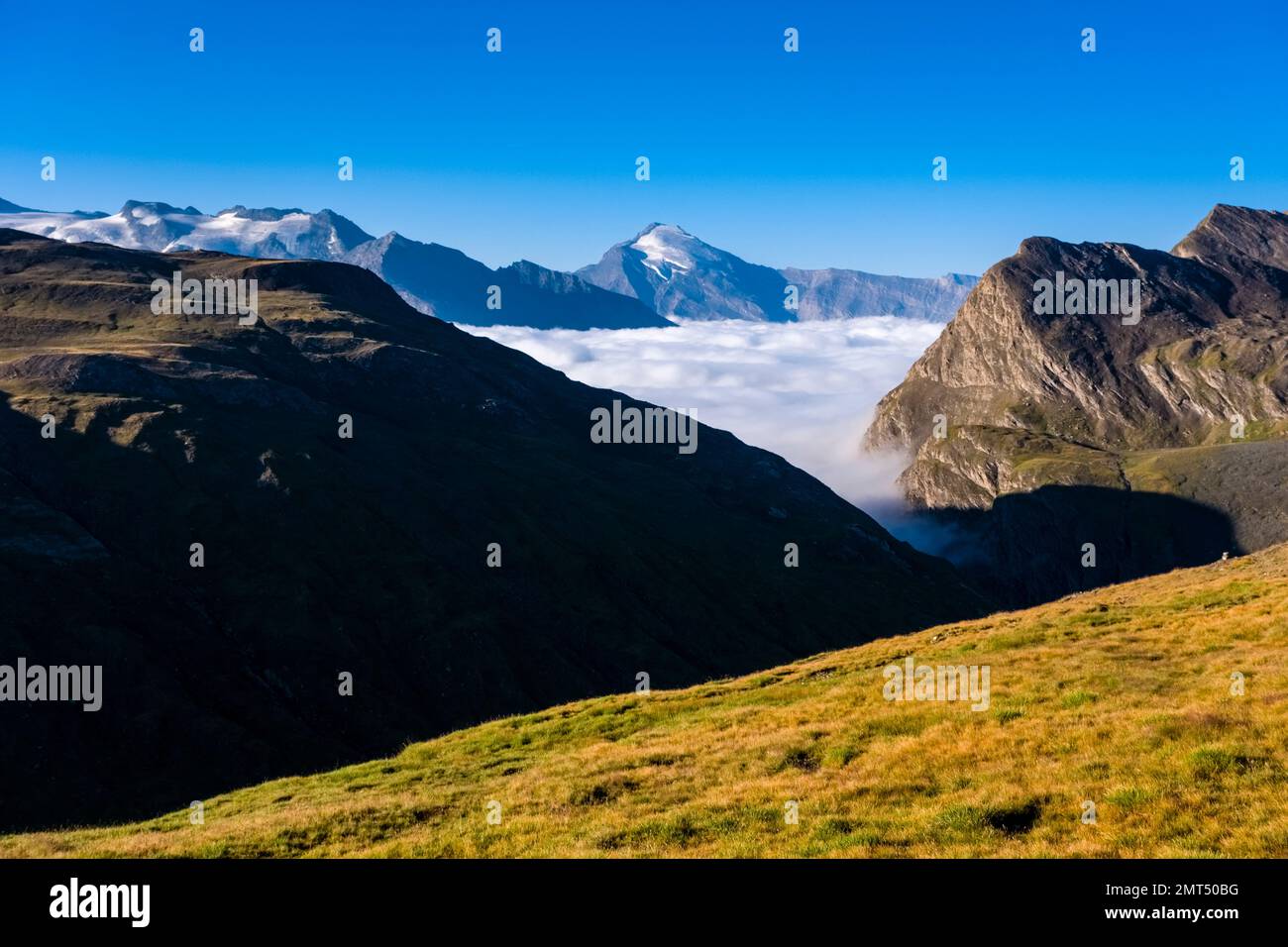 Berge und Hügel der Graianischen Alpen, von Col de L'Iseran aus gesehen 2770 m, der höchste asphaltierte Pass in den Alpen, das Tal voller Nebel. Stockfoto