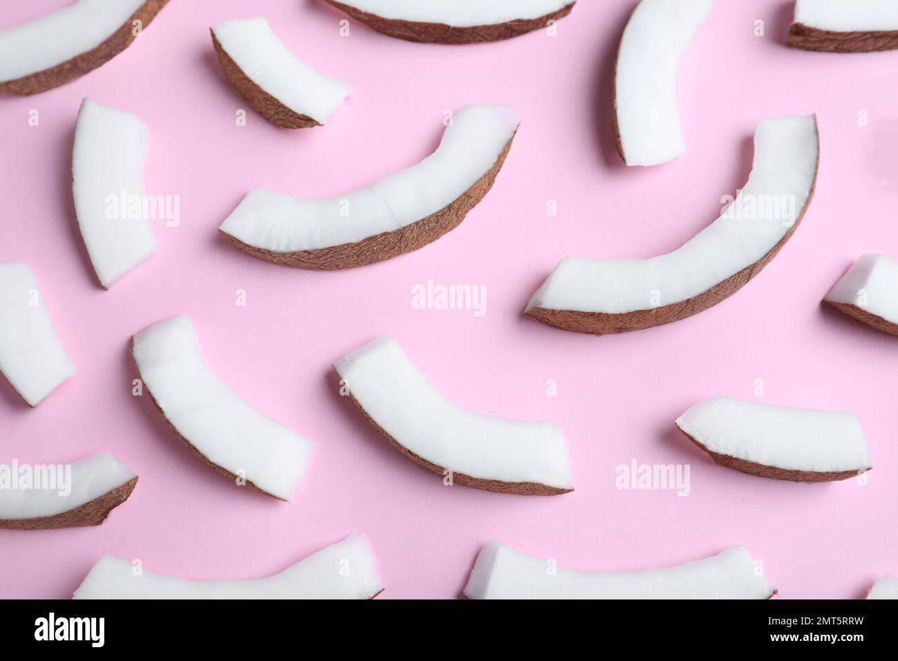 Frische Kokosnussteile auf rosa Hintergrund, über der Ansicht Stockfoto