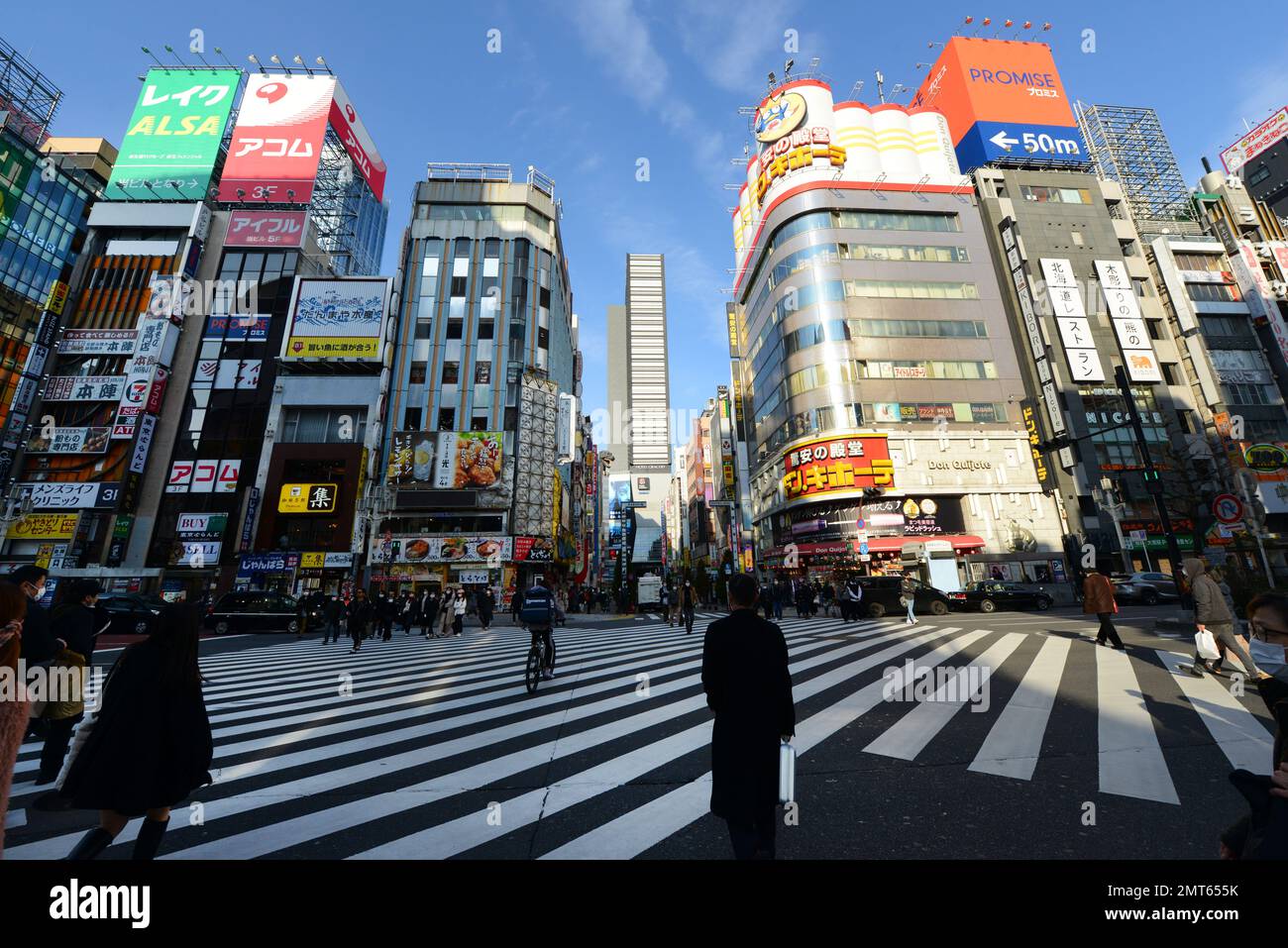 Fußgänger überqueren die Straße in Shinjuku, Tokio, Japan. Stockfoto