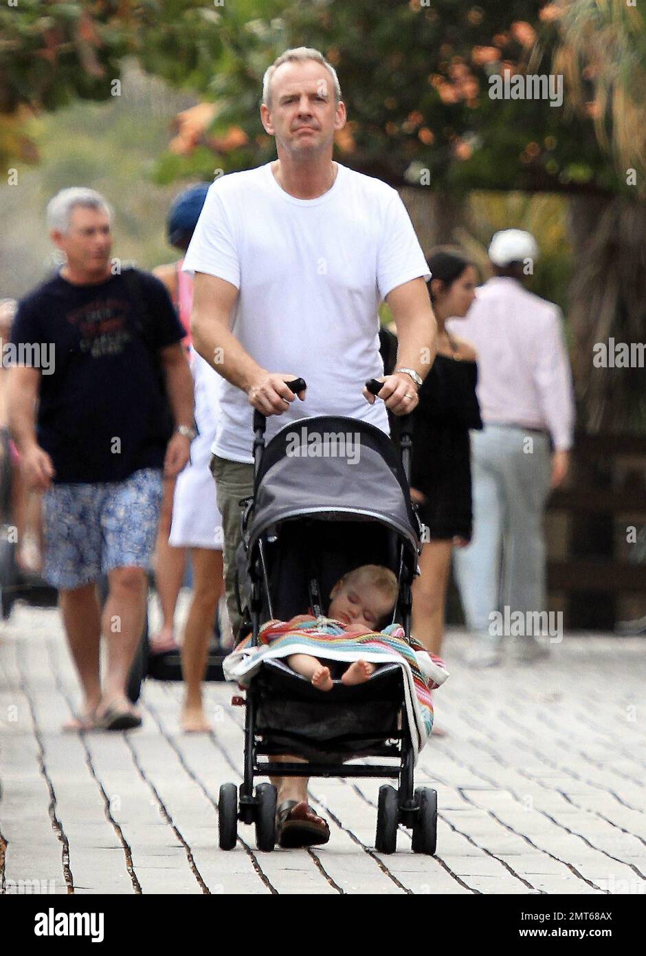 Norman Cook, auch bekannt als DJ Fatboy Slim, verbringt sich mit seiner bezaubernden, neuen Schlafenszeit-Tochter Nelly. Vor seiner Silvestervorstellung in South Beach machte Cook einen gemütlichen Spaziergang auf der Strandpromenade. Miami Beach, Florida 12/30/10. Stockfoto