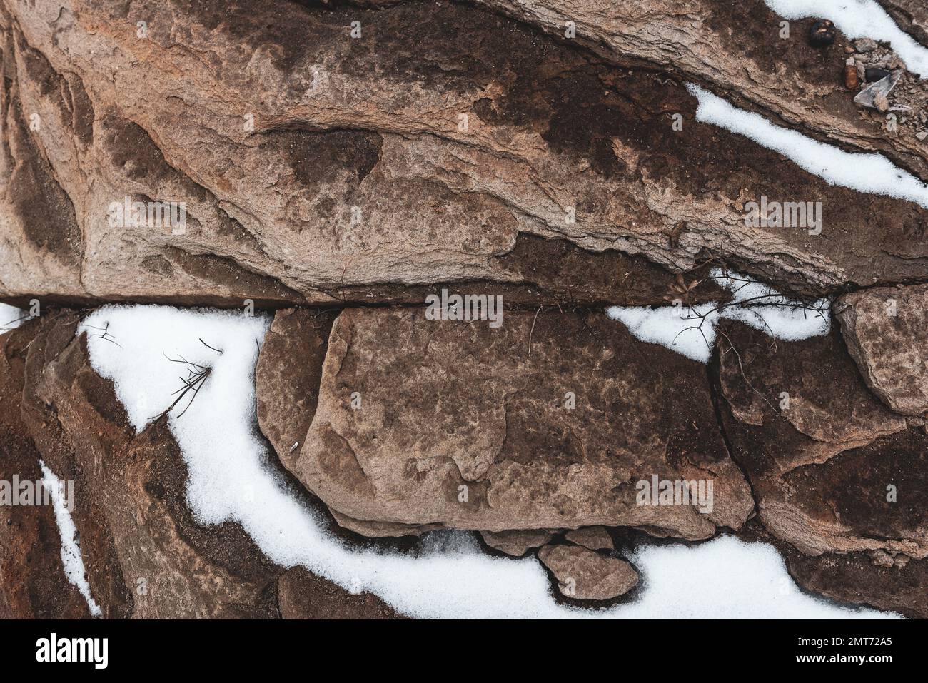 Steinklippe mit Schnee darauf. Stockfoto