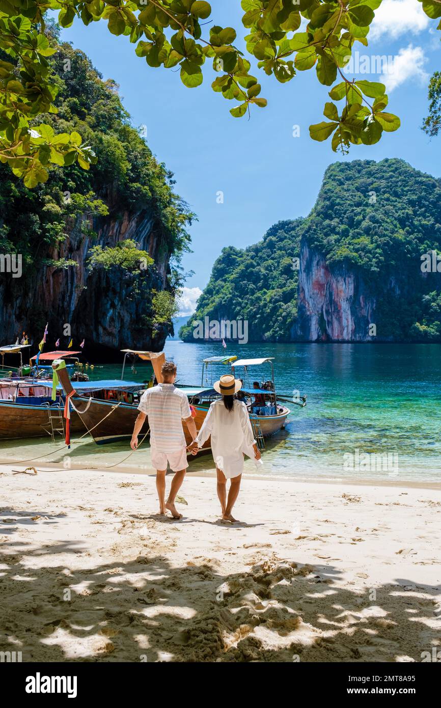 Männer und Frauen an der tropischen Lagune von Koh Loa Lading Krabi Thailand, Teil der Koh Hong Islands in Thailand. Wunderschöner Strand mit Kalksteinklippen und Langheckbooten Stockfoto