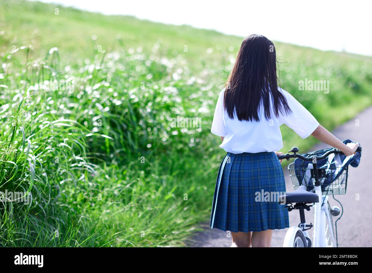 Japanische Highschool-Schülerin auf einem Fahrrad im Freien Stockfoto