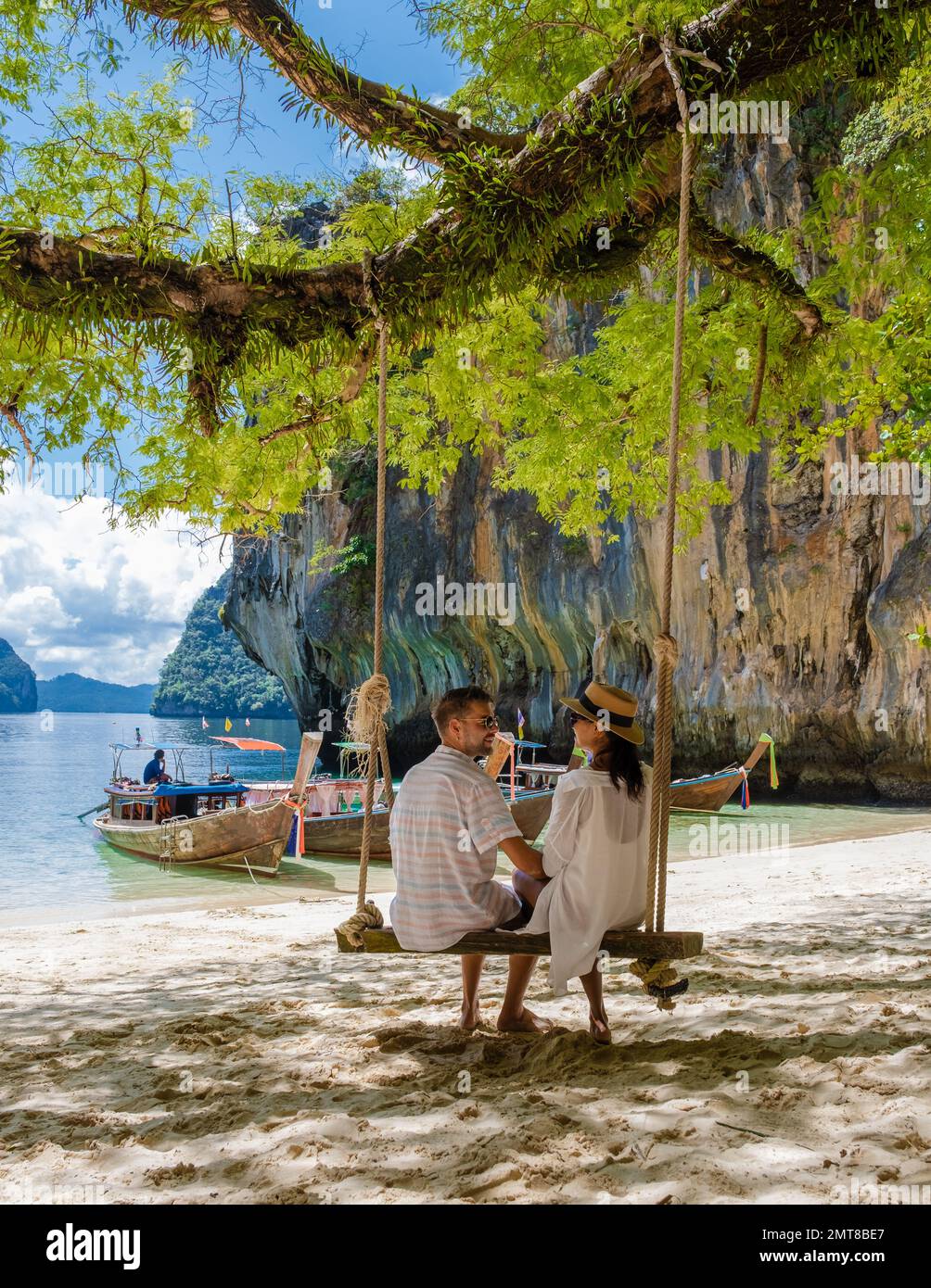 Männer und Frauen an der tropischen Lagune von Koh Loa Lading Krabi Thailand, Teil der Koh Hong Islands in Thailand. Wunderschöner Strand mit Kalksteinklippen und Langheckbooten Stockfoto