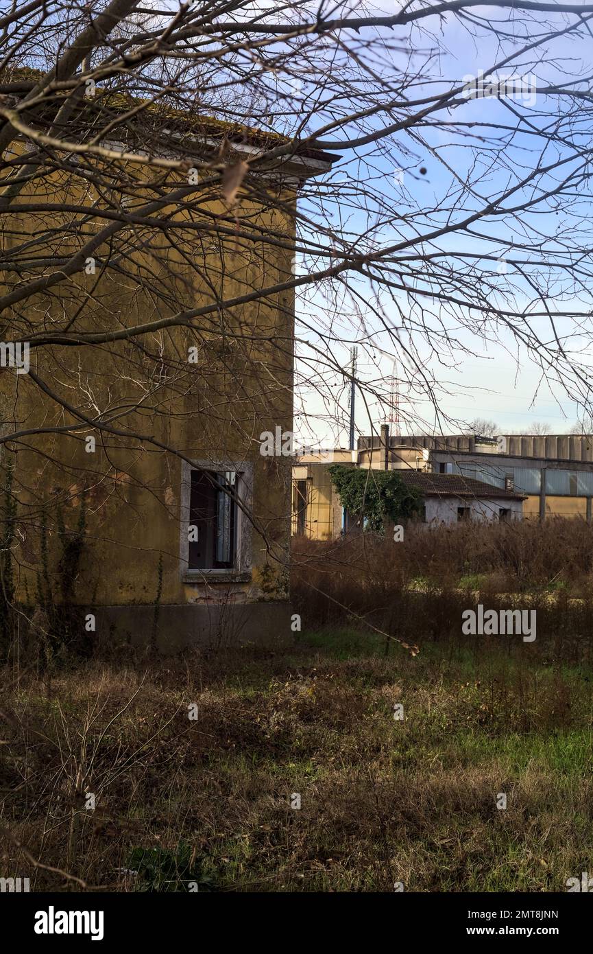 Verlassenes Industriegelände, das durch ein Tor auf dem italienischen Land geschlossen ist Stockfoto