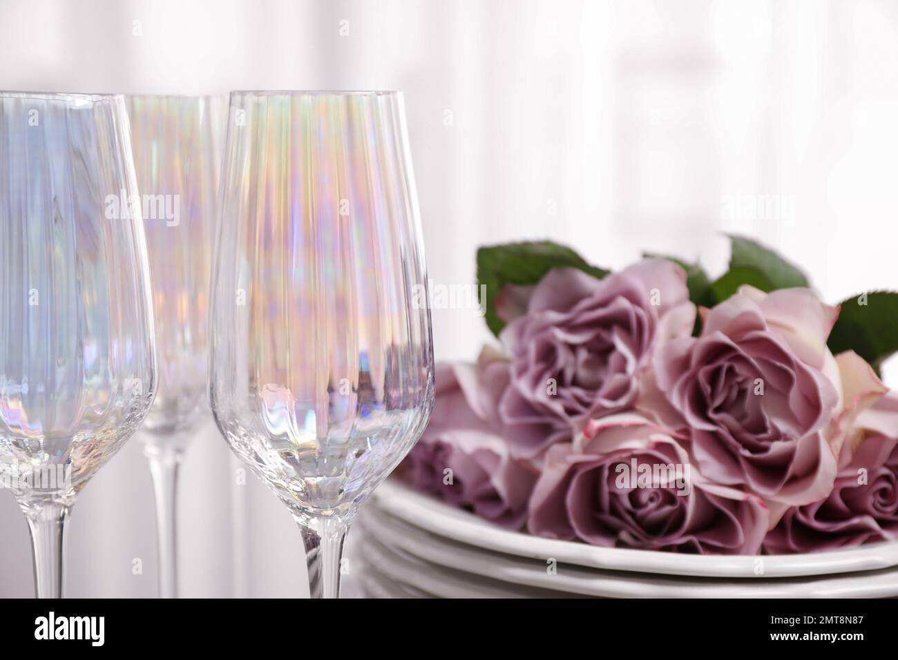 Gläser und Geschirr mit Blumen auf hellem Hintergrund, Nahaufnahme Stockfoto