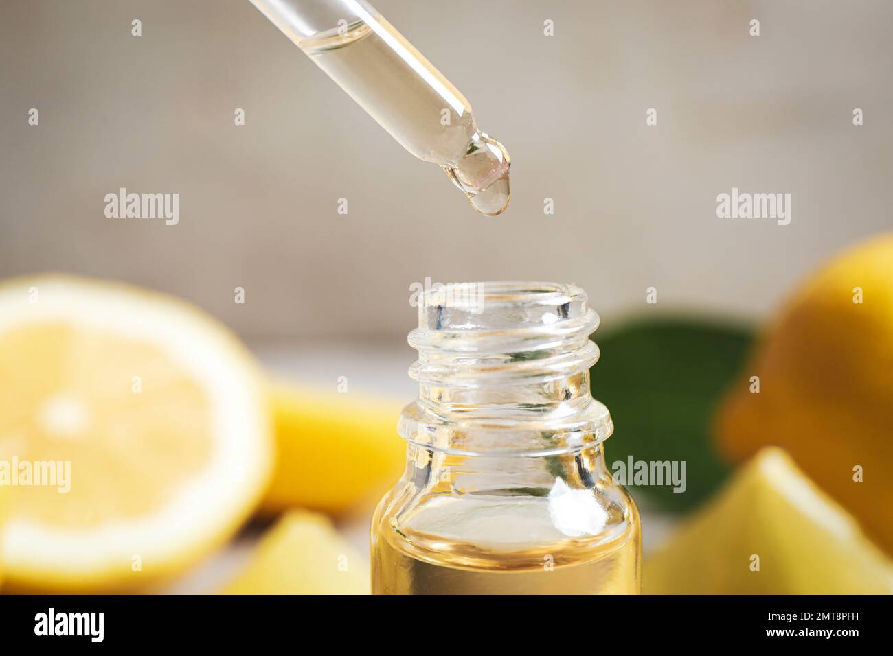Ätherisches Zitrusöl tropft aus der Pipette in die Flasche, Verschluss Stockfoto