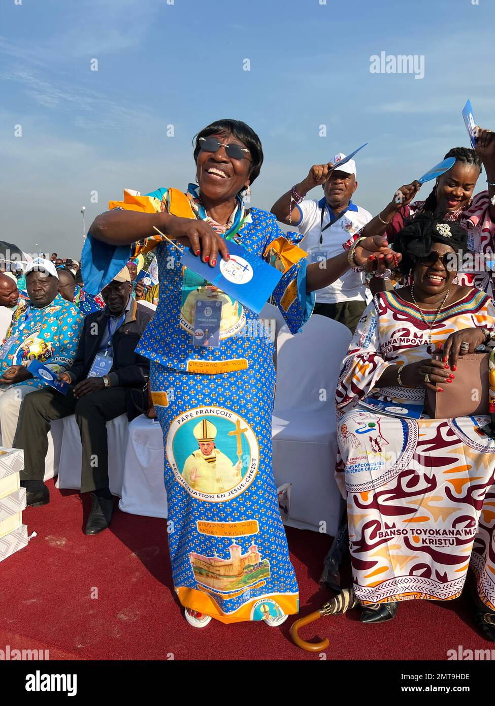 01. Februar 2023, Demokratische Republik Kongo, Kinshasa: Eine Frau tanzt auf dem Militärflugplatz von N'Dolo vor Beginn der Messe von Papst Franziskus in einem Kleid mit dem Porträt des Pontifex. Bei einer großen Messe in Kinshasa, an der mehr als eine Million Menschen teilnahmen, betete Papst Franziskus für ein Ende der Gewalt auf dem afrikanischen Kontinent. Er ermutigte die Menschen, "Friedensmissionen" zu sein und "mit allen zusammenzuarbeiten, um den Kreislauf der Gewalt zu durchbrechen und die Intrigen des Hasses zu zerschlagen". Das sagte er während seiner Heirat am Mittwoch in der Hauptstadt der Demokratischen Republik Kongo. Foto: Manuel Schwarz Stockfoto