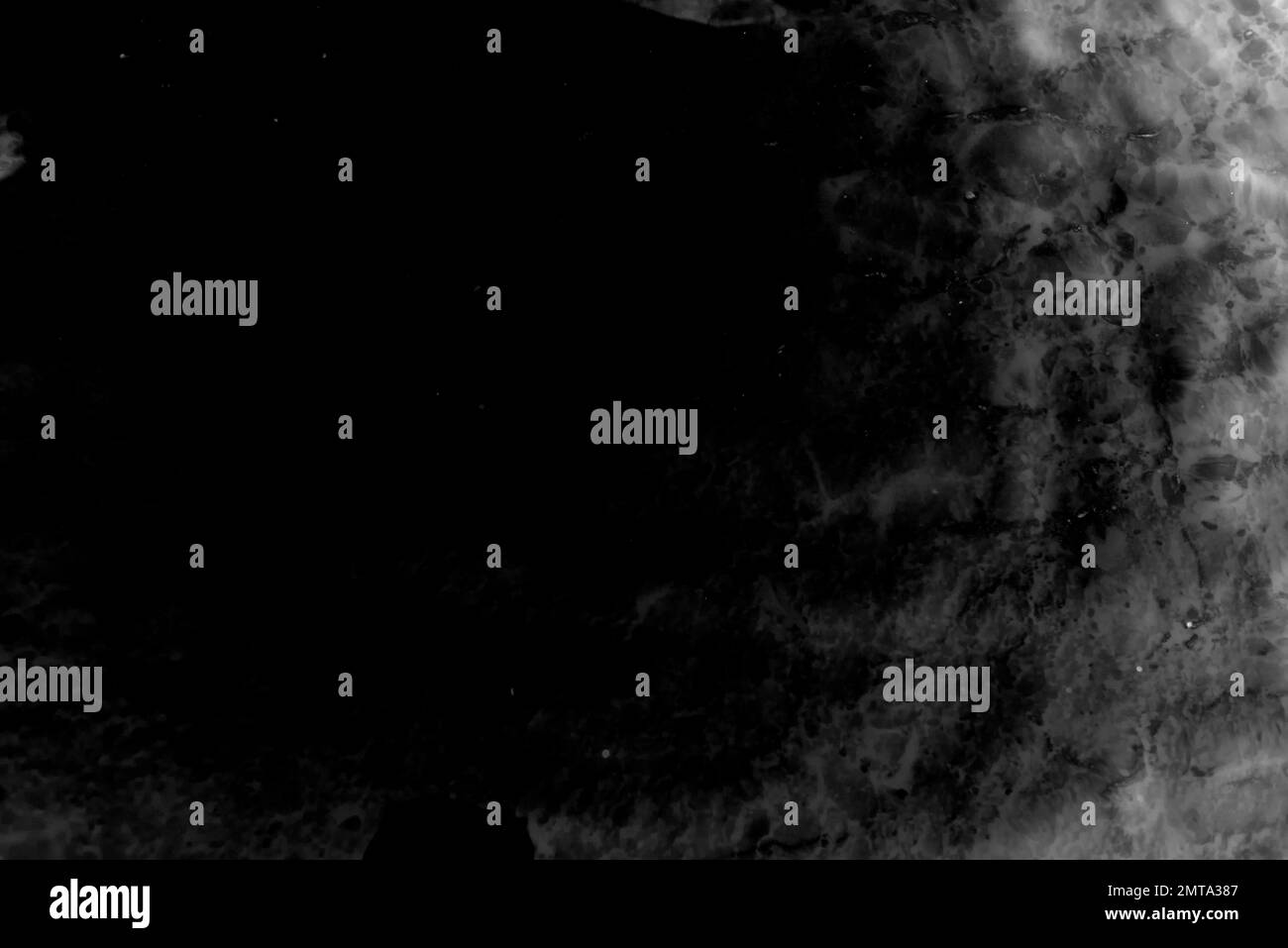 Schwarz-Weiß abstraktes Foto von Wasserwellen in Dunkelheit mit Lichtreflexion. Antikes Design. Hintergrund Stockfoto