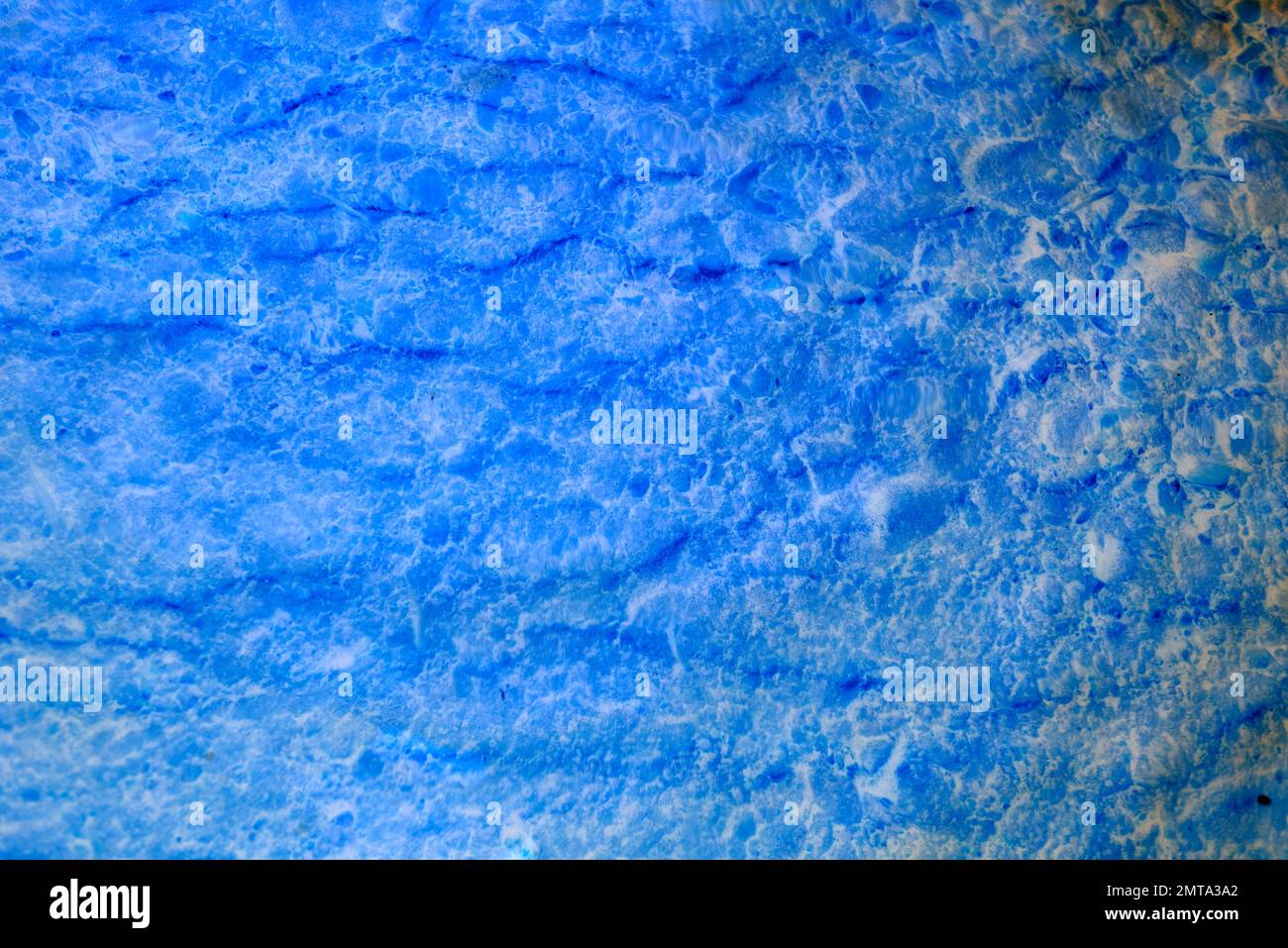 Abstraktes Foto von leuchtendem Neonblau mit transparenter Wassertextur mit Wellen und Boden. Stockfoto