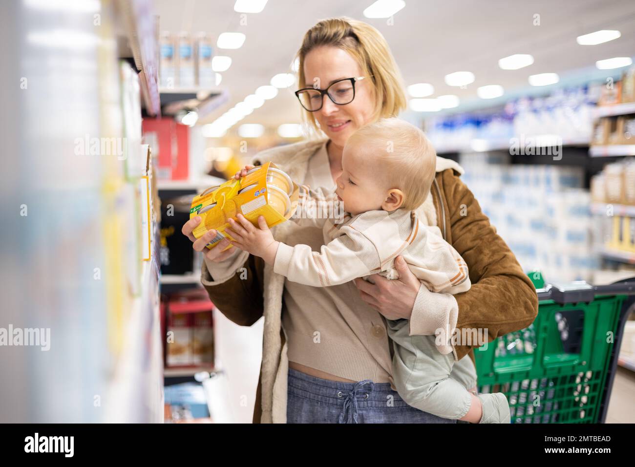 Kaukasische Mutter kauft mit ihrem kleinen Jungen Produkte aus dem Supermarkt ein Stockfoto