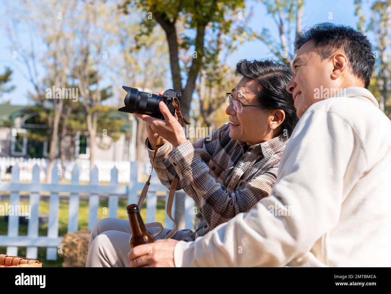 Zwei ältere Männer saßen auf einem Campingplatz und sahen eine Digitalkamera Stockfoto