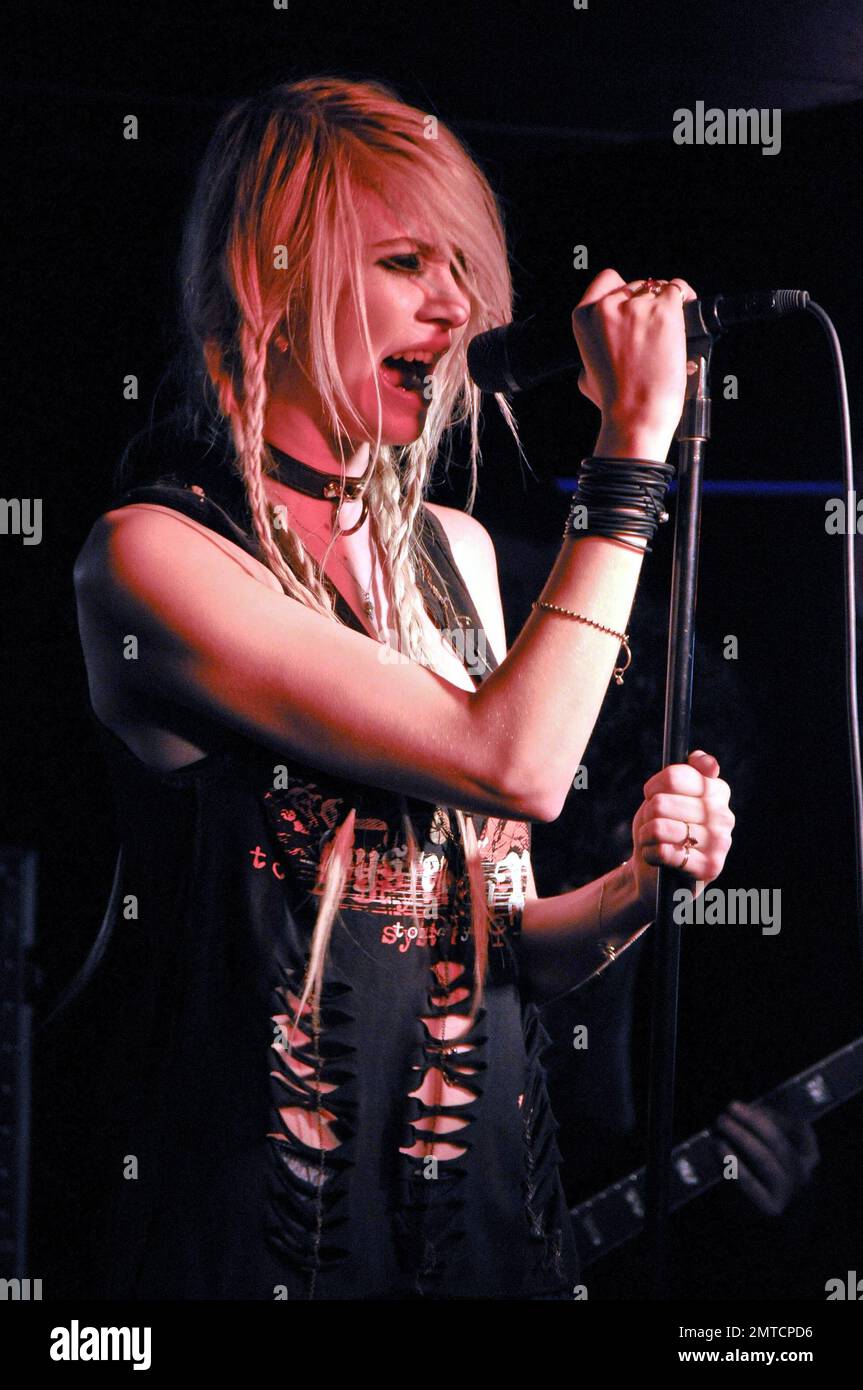 Taylor Momsen trägt eine schwarze Lederjacke und ein zerrissenes T-Shirt, das zu einem Kleid mit roten gemusterten Netzen und Stiefeln aus Lackleder mit superhohen Absätzen gepaart wurde. In der Wonder Bar in Asbury Park, NJ 3/18/11, tritt sie live mit ihrer Band The Pretty Reckless auf. Stockfoto