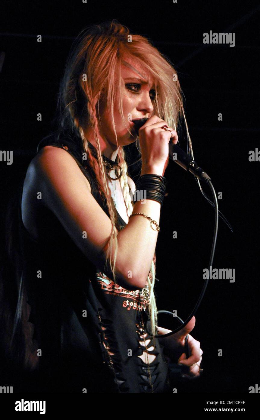 Taylor Momsen trägt eine schwarze Lederjacke und ein zerrissenes T-Shirt, das zu einem Kleid mit roten gemusterten Netzen und Stiefeln aus Lackleder mit superhohen Absätzen gepaart wurde. In der Wonder Bar in Asbury Park, NJ 3/18/11, tritt sie live mit ihrer Band The Pretty Reckless auf. Stockfoto