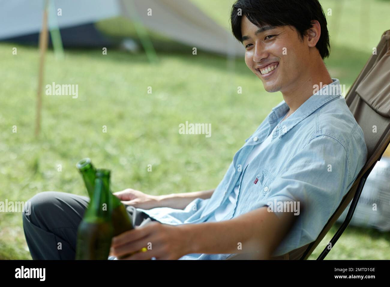 Junger Japaner auf dem Campingplatz Stockfoto