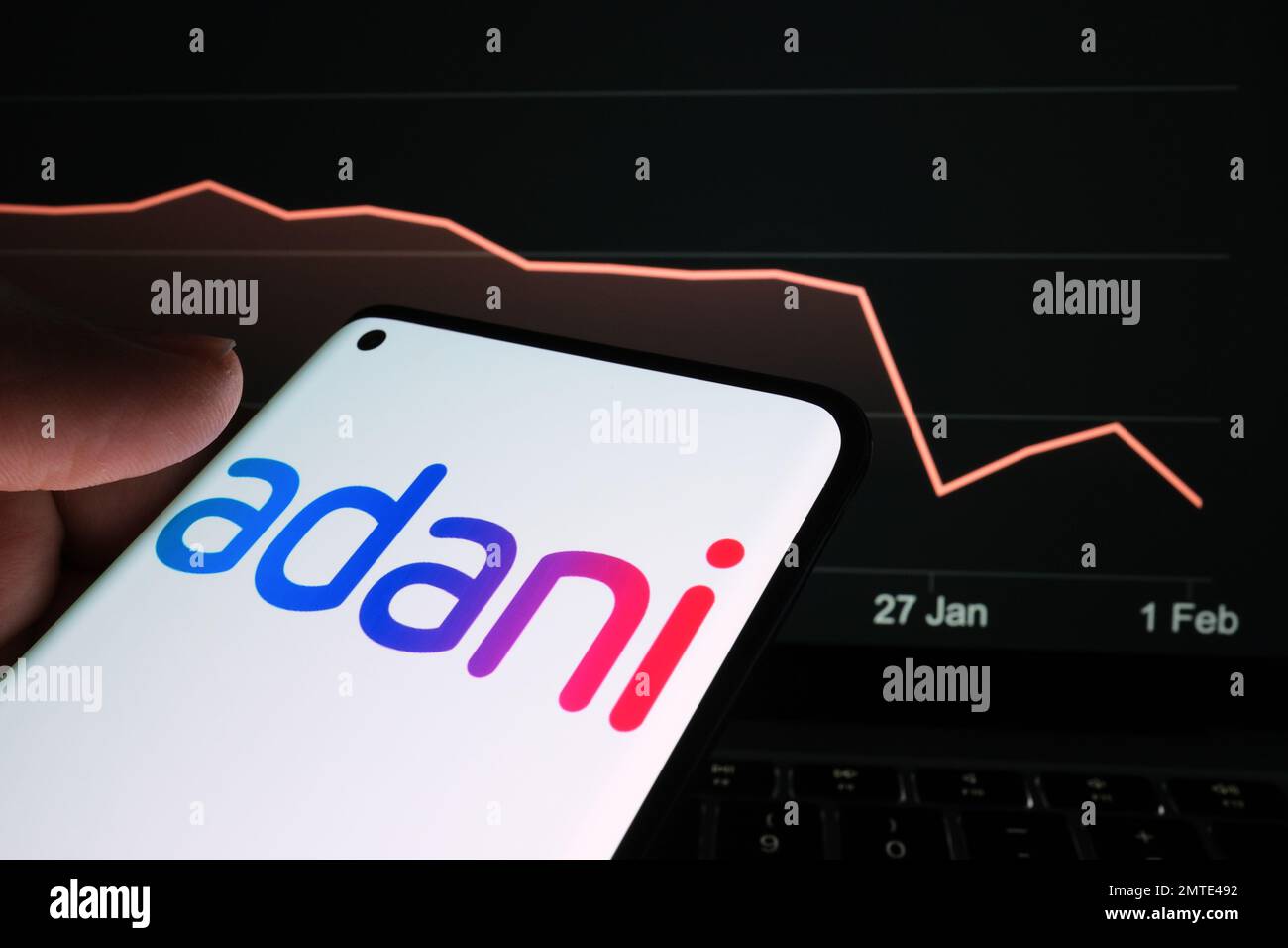 Logo der Adani Group auf dem Smartphone-Bildschirm und Diagramm des Aktienkurses des Unternehmens auf unscharfem Hintergrund. Reales Aktiendiagramm für einen Monat Stockfoto