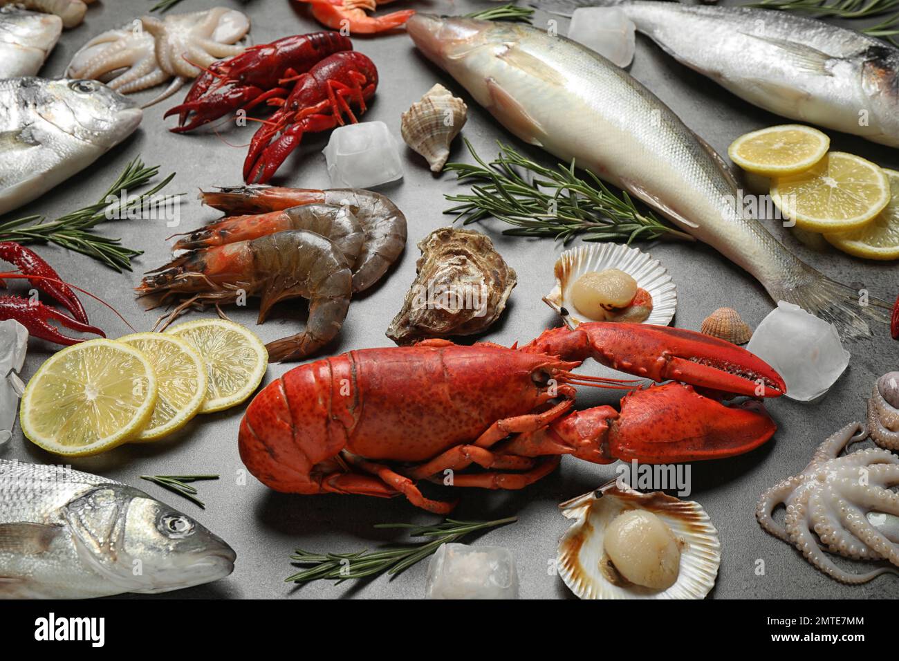 Frischer Fisch und verschiedene Meeresfrüchte auf grauem Tisch Stockfoto