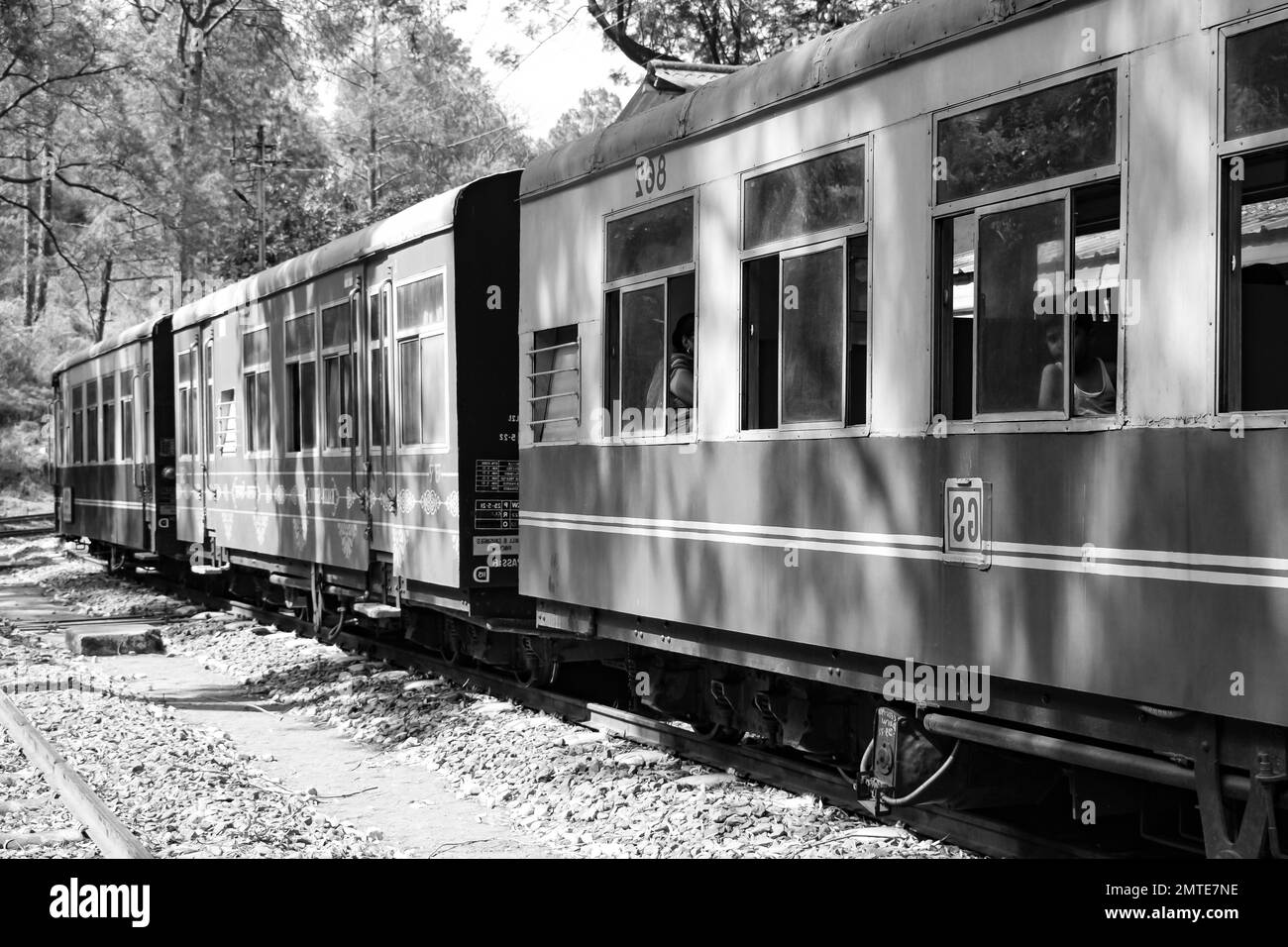 Der Spielzeugzug bewegt sich auf einem Berghang, wunderschöne Aussicht, eine Seite des Berges, eine Seite des Tals bewegt sich mit der Eisenbahn zum Hügel, inmitten eines grünen Naturwaldes. Spielzeug Stockfoto