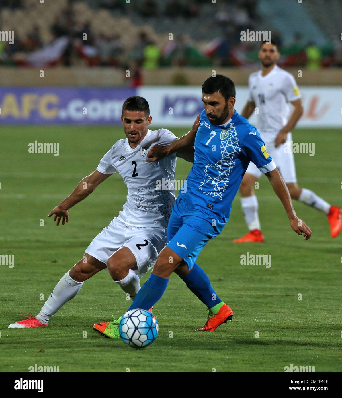 Iran's Milad Mohammadi, left, and Uzbekistan's Azizbek Khaydarov, vie for the ball during their 2018 Russia World Cup qualifying soccer match at the Azadi Stadium in Tehran, Iran, Monday, June 12, 2017. Iran became the second team to qualify for the 2018 World Cup by beating Uzbekistan 2-0 on Monday. (AP Photo/Vahid Salemi) Stockfoto