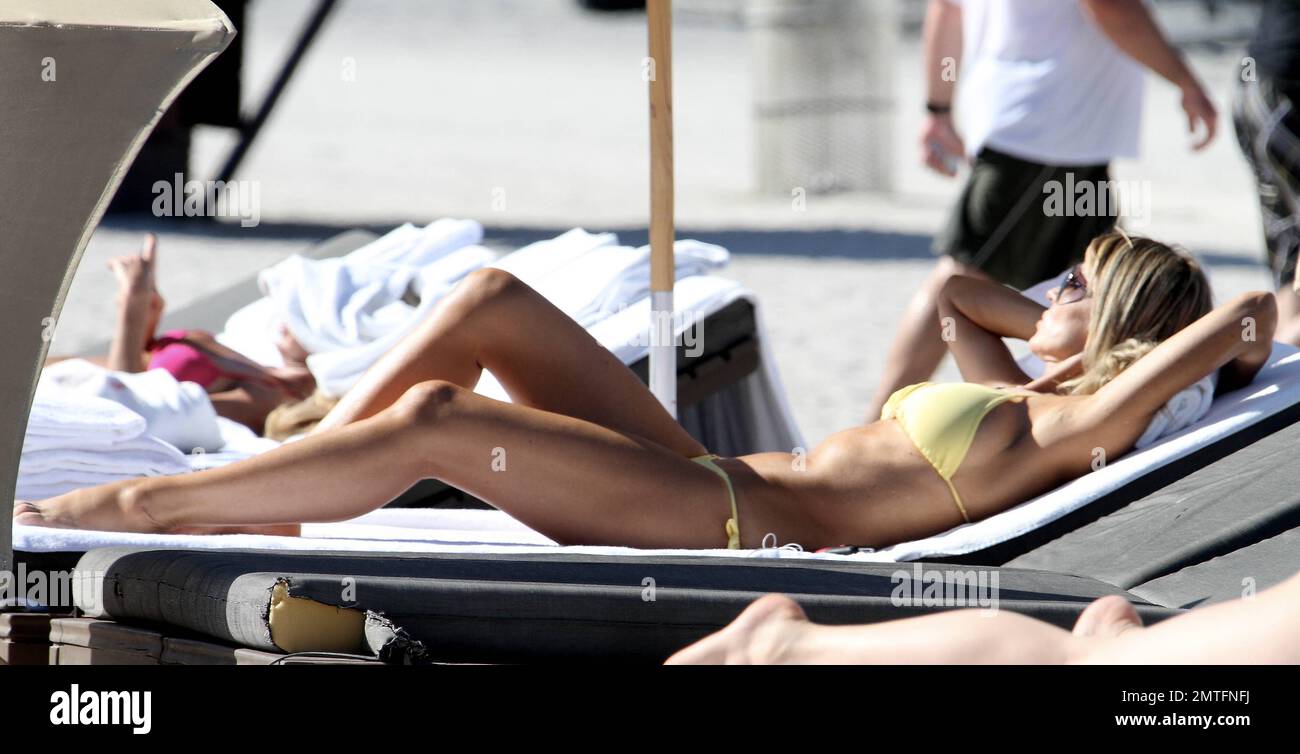 Rita Rusic verbrachte den Tag wieder am Strand mit ihrem Freund. Rita sah einmal so aus, als hätte sie einen maßgeschneiderten Bikini von einem lokalen Bikiniverkäufer bestellt. Später trank Rita und ihre Begleiterin ein paar Cocktails und paddelte dann im Meer. Sie machte ein paar Fotos mit vorbeifahrenden Fans. Miami Beach. Fl. 21. Januar 2012. Stockfoto