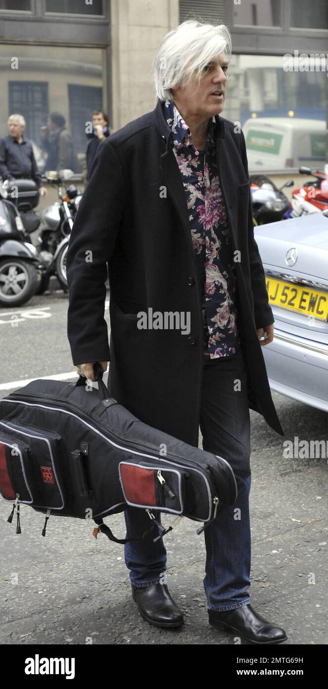 Sänger Robyn Hitchcock trägt seine Gitarre, wenn er zu einem Auftritt bei der BBC in London, Großbritannien, ankommt. 5/10/10. Stockfoto