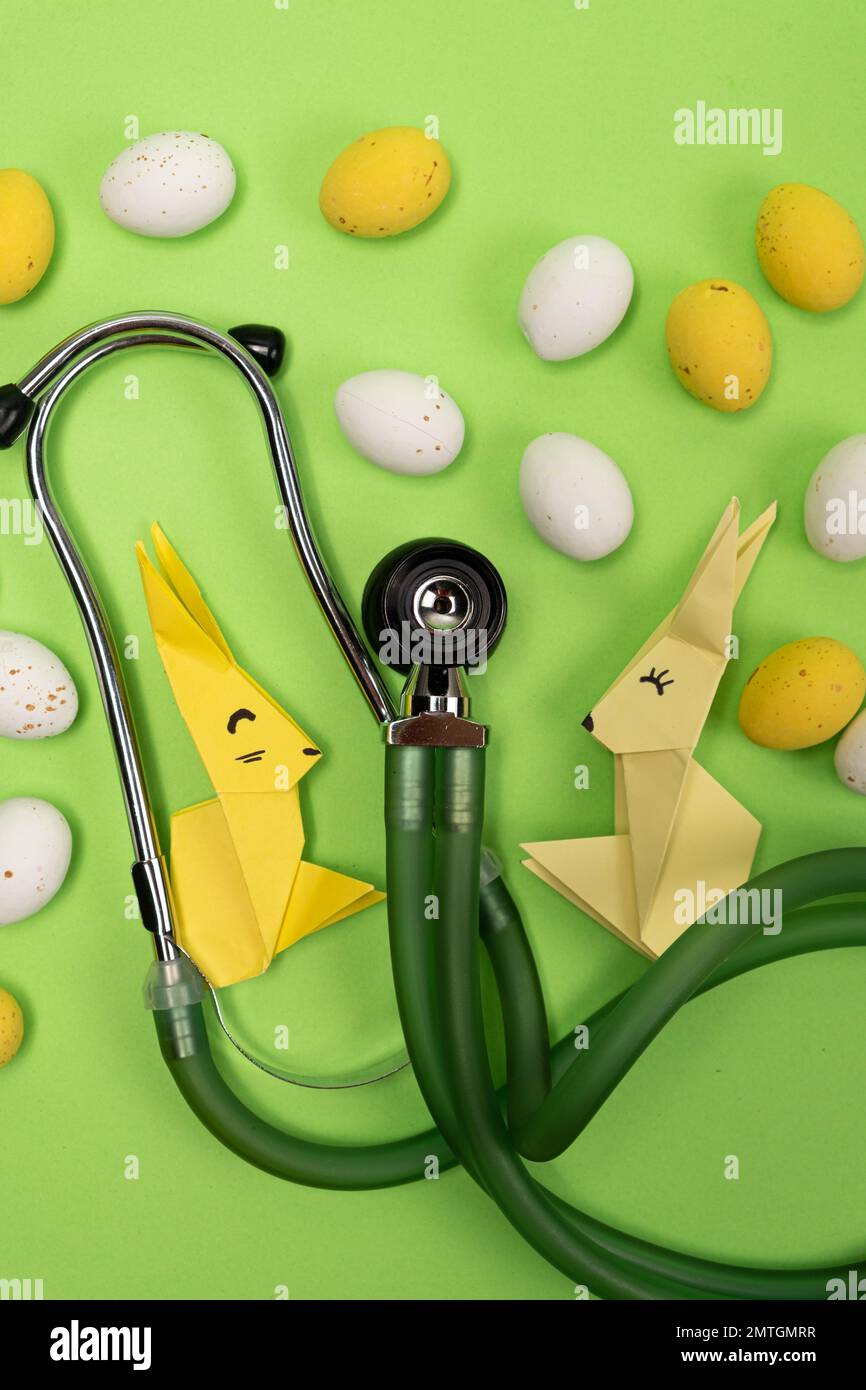 Fröhliche und gesunde Ostern - medizinische Karte mit Stethoskop, Osterhasen und Eiern. Stockfoto