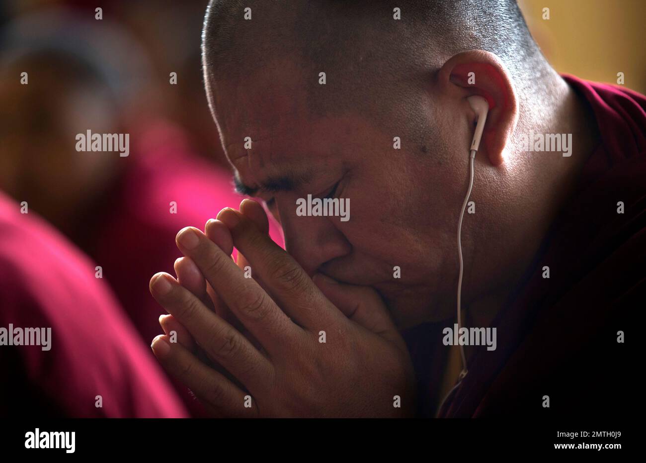 A Tibetan Buddhist monk prays as he listens to his spiritual leader the Dalai Lama during a religious talk at the Tsuglagkhang temple in Dharmsala, India, Wednesday, June 7, 2017. Each year the Tibetan leader talks to young Tibetans on Buddhist philosophy and selected texts. The three-day talk ended Wednesday. (AP Photo/Ashwini Bhatia) Stockfoto