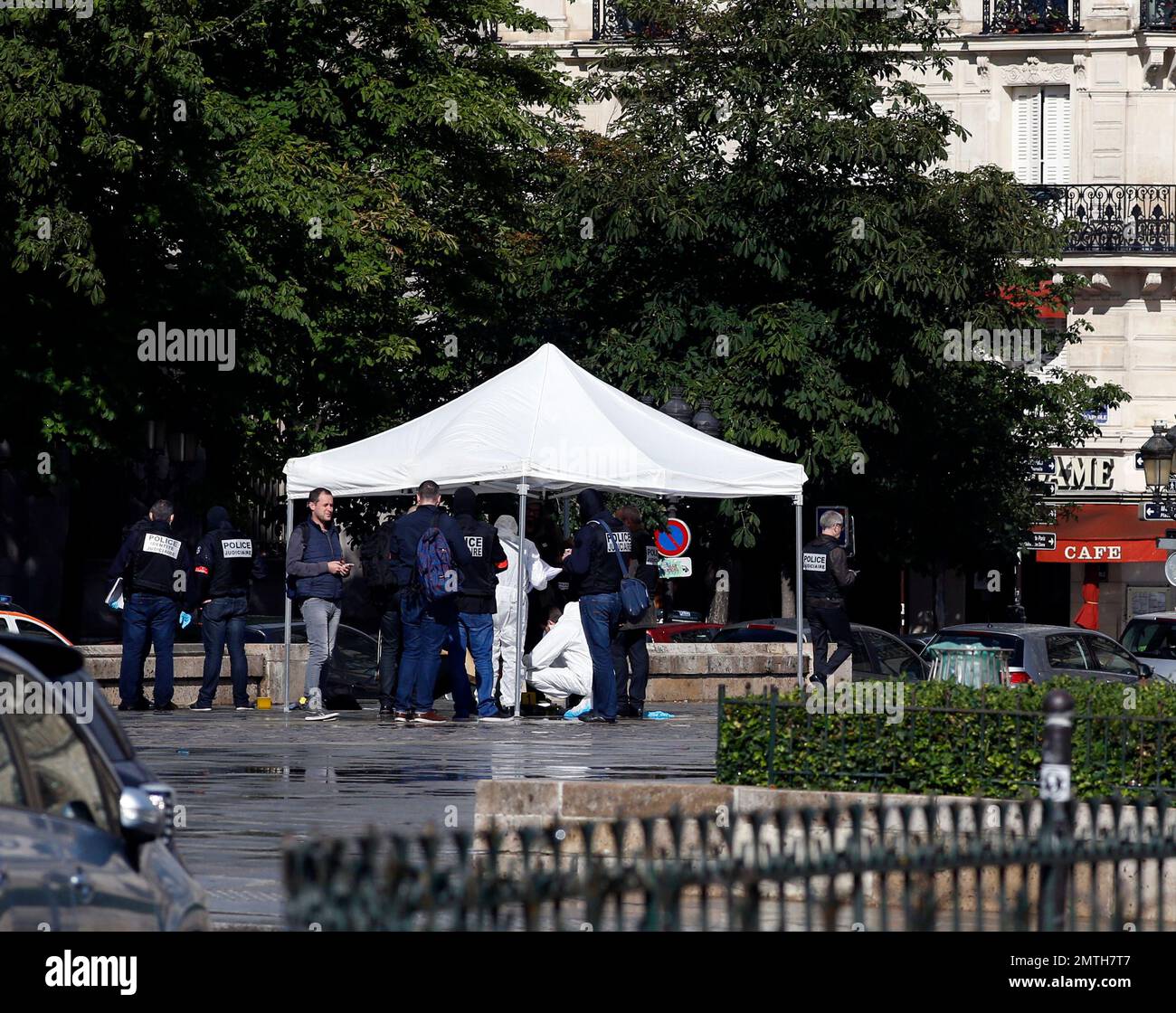 Forensic experts and police officers investigate the crime scene after