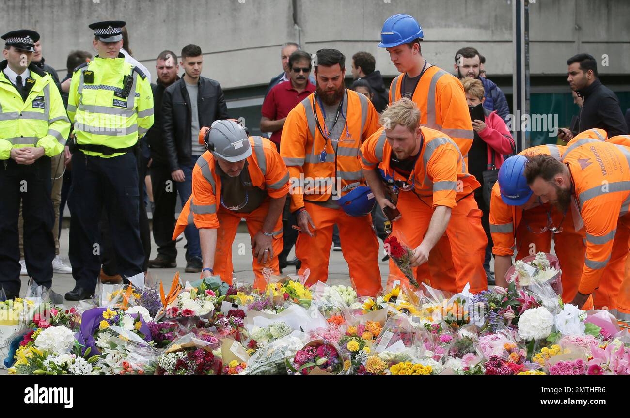 City workers lay flower tributes in the London Bridge area of London, Monday, June 5, 2017. Police arrested several people and are widening their investigation after a series of attacks described as terrorism killed several people and injured more than 40 others in the heart of London on Saturday. (AP Photo/Tim Ireland) Stockfoto