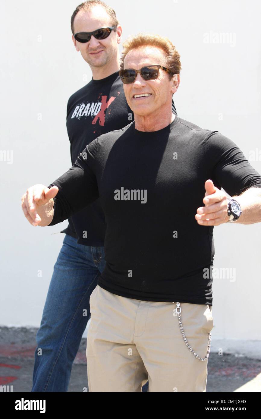 Arnold Schwarzenegger blickt auf tof The World zurück, als er am 30. Juli 2011 im Café Roma in Beverly Hills mit seinem Sohn Patrick zu Mittag isst, der mit der Paparazzi-Aufmerksamkeit, LA, CA, weniger als behaglich aussieht. Stockfoto