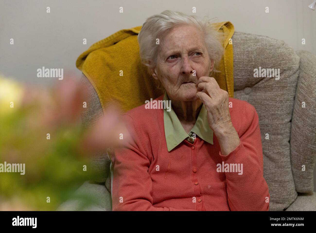 Ältere Frau in ihren 80ern, die in einem Pflegeheim-Schlafzimmer in England lebt Stockfoto