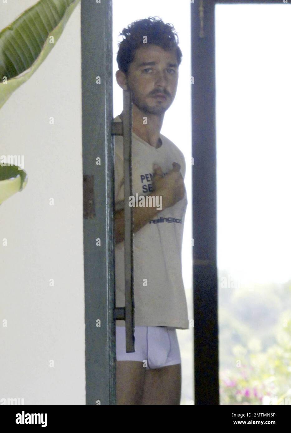EXKLUSIV!! Der Stern Shia Lebeouf, der dunkle Star des Mondes, sieht aus, als wäre er gerade aufgestanden, als er in einem T-Shirt und Unterwäsche an die Tür geht. Los Angeles, Kalifornien. 7/1/11. Stockfoto