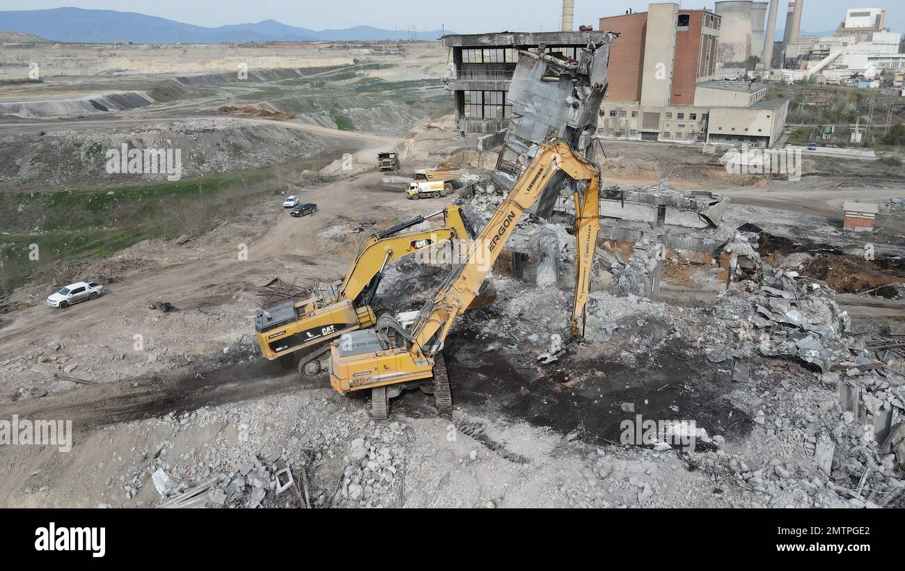 Hydraulikbagger mit Hydraulikhammer zum Abreißen eines Industriegebäudes. Stockfoto