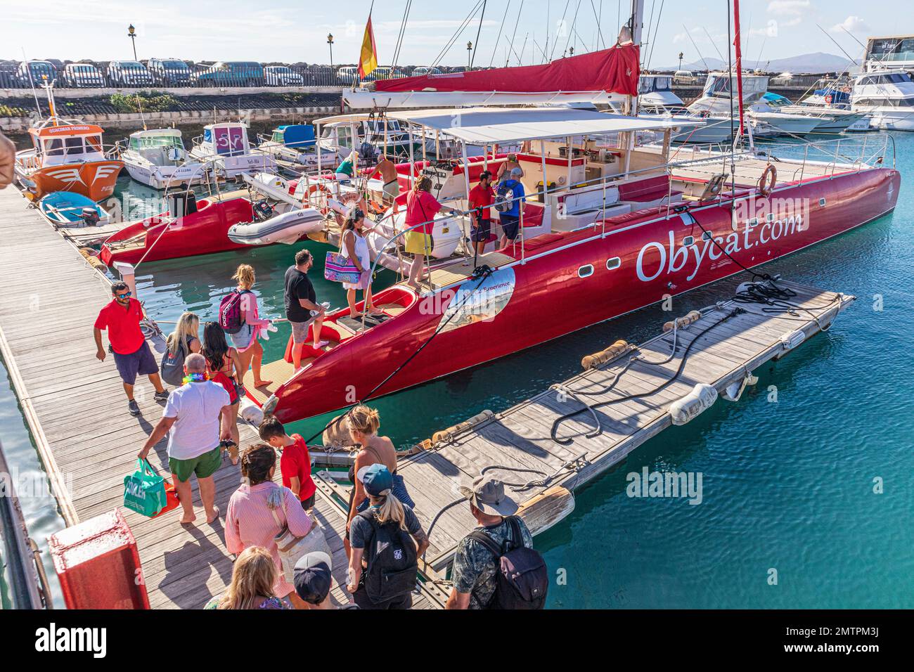 Touristen, die an Bord des Obycat Experience Katamarans gehen, fahren im Hafen von Caleta de Fuste an der Ostküste der Kanarischen Insel Fuerteventura, Spanien Stockfoto