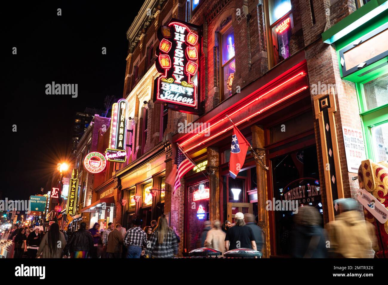 Nashville, Tennesee - 21. Januar 2023: Straßenszene des berühmten Lower Broadway in Nashville, Tennessee, bei Nacht mit Lichtern und historischem Honky-to Stockfoto