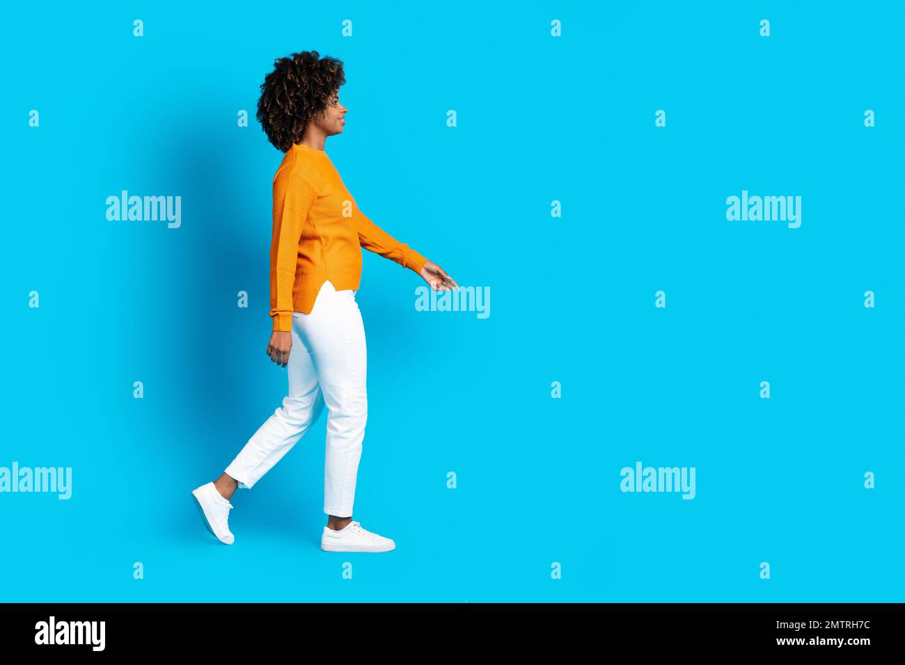 Coole, schicke, geschwungene schwarze Frau, die in Richtung Kopierbereich geht Stockfoto
