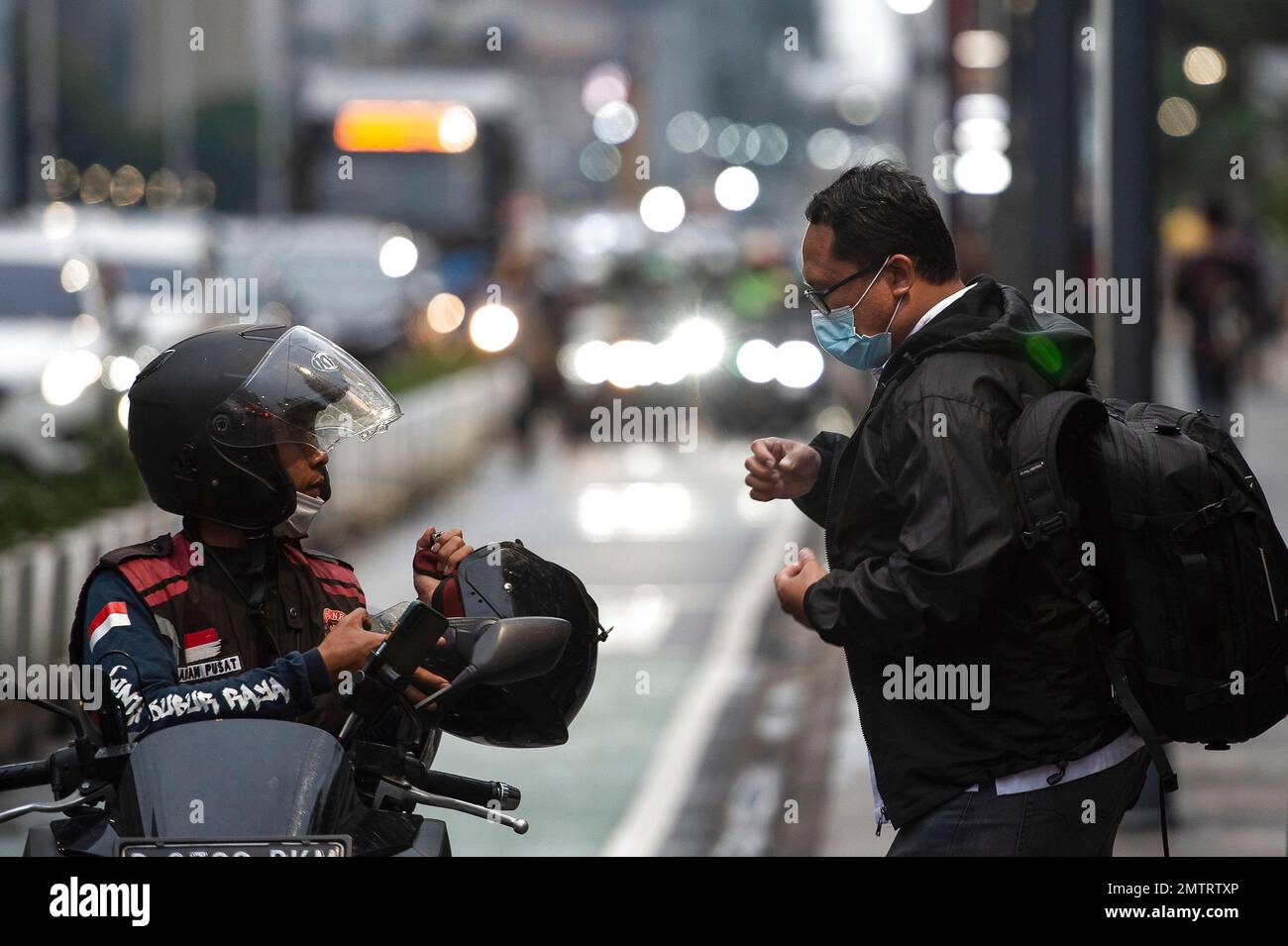 Jakarta, Indonesien. 1. Februar 2023. Ein Mann, der eine Fahrt braucht, spricht mit einem Taxifahrer auf dem Bürgersteig der Thamrin Street in Jakarta, Indonesien, am 1. Februar 2023. Indonesien verzeichnete im Januar gegenüber dem Vorjahr eine Inflation von 5,28 Prozent, die niedrigste seit August 2022, aber sie übertraf nach Angaben der Statistikbehörde Indonesien BPS am Mittwoch immer noch das Ziel der Zentralbank. Kredit: Veri Sanovri/Xinhua/Alamy Live News Stockfoto