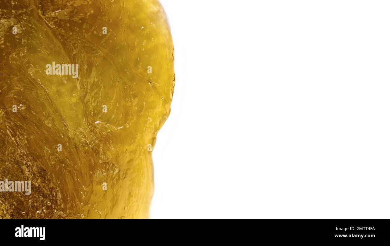 Gelb-transparente Textur des kosmetischen mittels isoliert auf weißem Hintergrund. Flüssige gelbe Zuckerpaste oder Wachs zur Nahaufnahme der Enthaarung. Stockfoto
