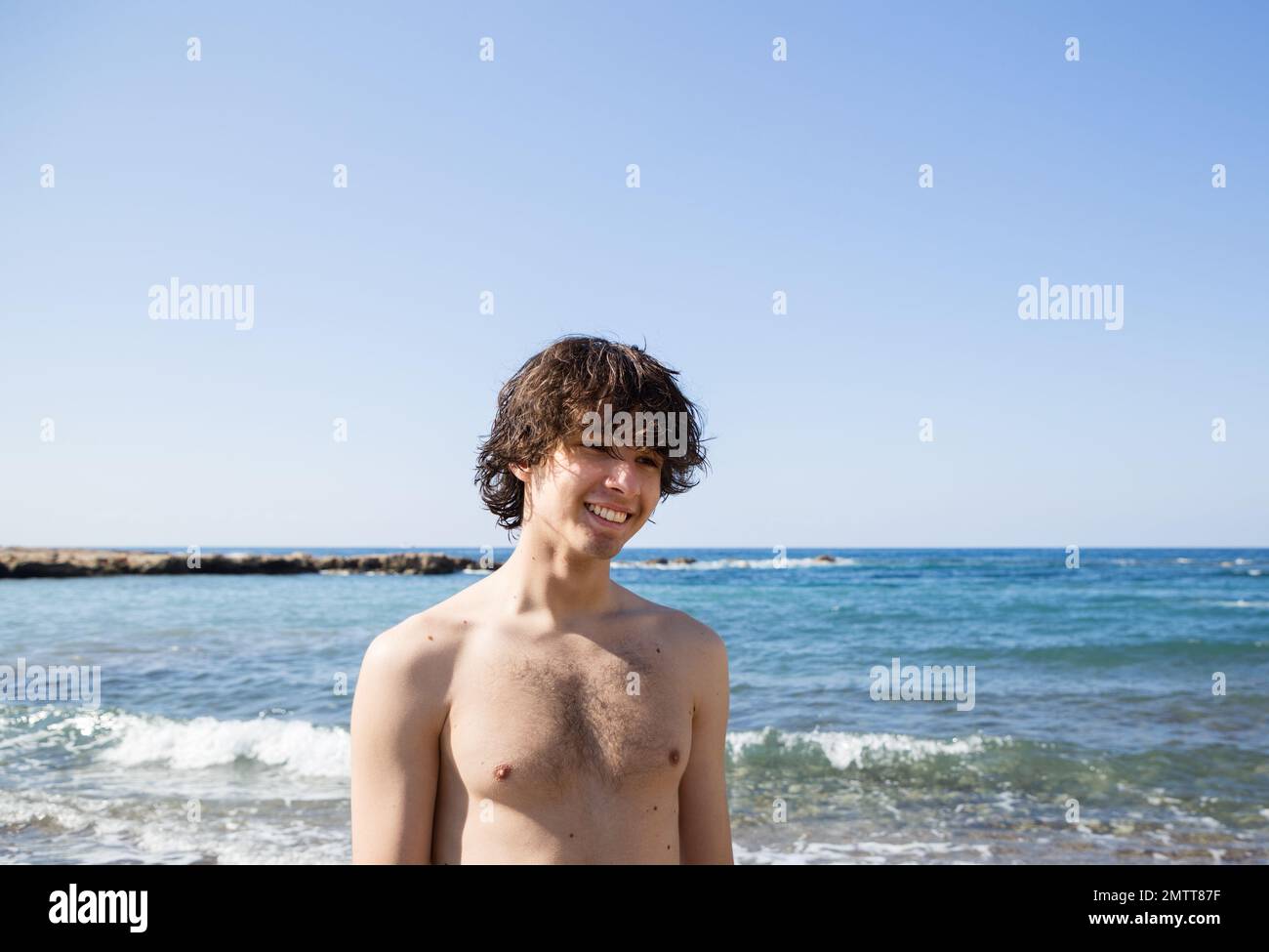 Porträt eines 18 -19-jährigen jungen Mannes an der Seeküste. Freude, Entspannung, gesunder Lebensstil, Energie der Natur. Sommerferien Stockfoto